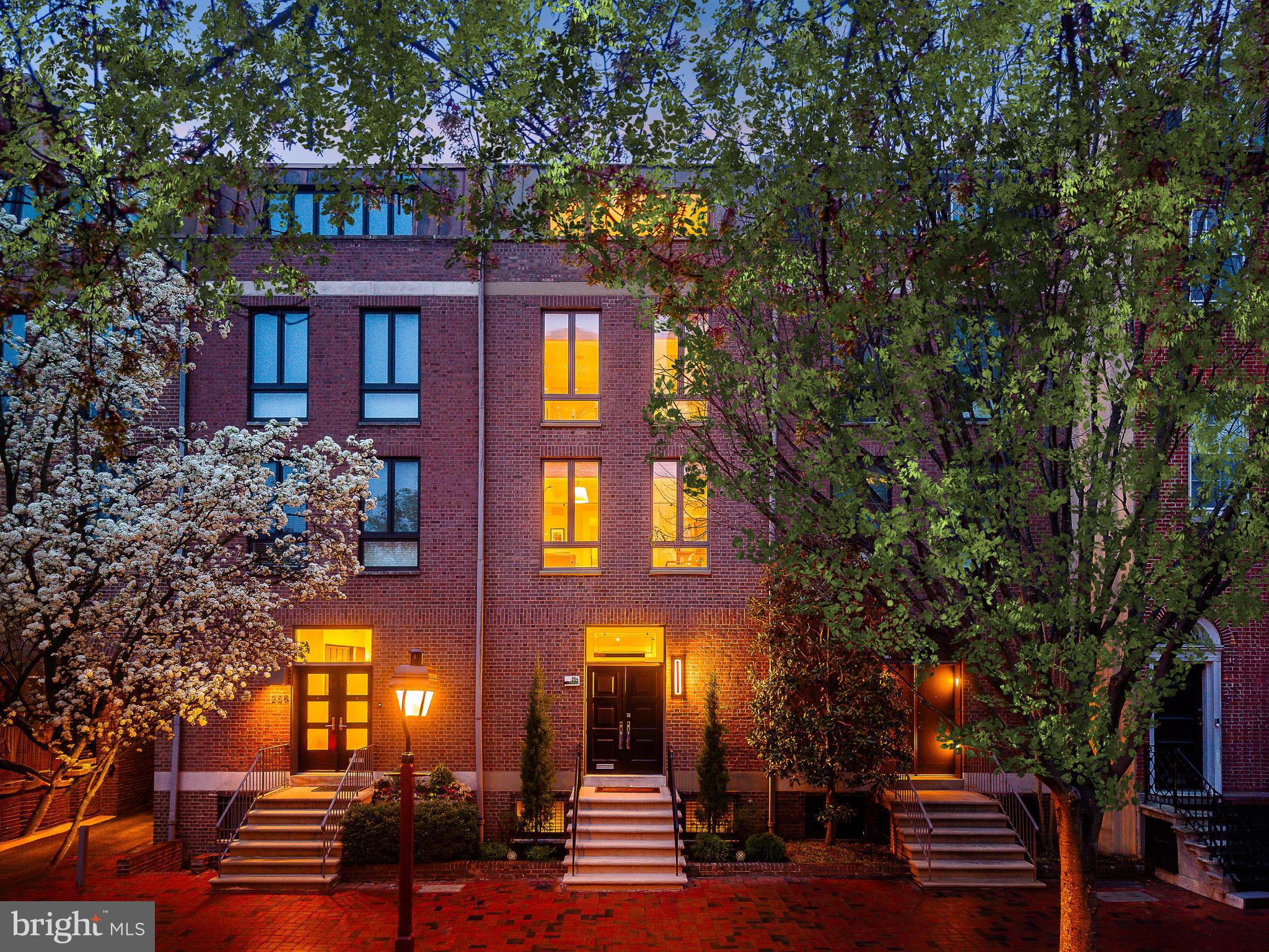 Set along a picturesque, tree-lined block in one of Society Hill’s most coveted enclaves, 254 S. 3rd Street offers a rare combination of scale, sophistication, and modern luxury. Positioned on an unusually wide stretch of 3rd Street and set back from the sidewalk, this residence blends historic charm with a sense of privacy and quiet elegance rarely found in Philadelphia.
Spanning over 3,900 square feet across five impeccably finished levels, this 18-foot-wide home features 3 bedrooms,  3 full and 2 half baths, elevator access to every floor. The property includes gated parking for four cars.
The stately brick façade is timeless and refined, leading to impressive double entry doors. Originally designed by Bloomfield & Associates and fully renovated in 2022, the home reflects a philosophy of understated luxury.
Inside, a sweeping sculptural staircase serves as the home’s architectural centerpiece, gracefully connecting all five levels. Its curved design, wood treads, and custom metal railing create a striking visual statement, while a dramatic circular skylight above fills the space with natural light throughout the day.
The entry level is both functional and elegant, featuring wide-plank oak floors and tray ceilings. A custom wet bar with Sub-Zero refrigeration and a Bosch dishwasher is seamlessly integrated into the foyer. A discreet mudroom and powder room add to the home’s functionality. The living room is anchored by a gas fireplace and opens through oversized French doors to an enclosed rear patio. This private outdoor space and garden allow for entertaining and connects directly to the gated parking courtyard, offering rare tranquility with no rear road exposure.
The second level houses the sunlit family room with expansive Eastern facing windows flowing into the dining area. A beautifully renovated kitchen is designed with custom cabinetry, quartz countertops, Sub-Zero refrigeration and wine storage, Thermador gas range with vented hood, and a Bosch dishwasher. A concealed coffee bar, custom pantry, and oversized island enhance everyday living, while a private balcony with a grill extends the space outdoors, overlooking the private tree-lined canopy.
The primary suite enjoys warm Western light and a peaceful, retreat-like setting. Generously scaled, it features custom-fitted closets and ensuite bath with premium finishes, including a Toto Neorest 700H smart toilet. A secondary bedroom at the front of the home benefits from soft morning light and offers versatility as a guest suite, office, or additional living space. 
The top level offers a third bedroom with an en-suite bath and walk-in closet, along with access to a rooftop terrace. From this level, enjoy sweeping skyline views, including the iconic Benjamin Franklin Bridge, while the architectural skylight continues to bring natural light deep into the home.
The finished lower level provides flexible living space ideal for a media room, gym, or playroom, complete with a full bath, laundry, and ample storage. A striking glass-enclosed wine display beneath the staircase adds a sophisticated focal point.
The 2022 renovation prioritized infrastructure and comfort with a new roof, new hardwood floors throughout, new curb trap and drain and a modern upgrade to finishes. This home is equipped with 3 Toto Neorest 700H smart toilets and 2 Toto 550 E washlets, built-in closet systems, electronic shades, two irrigation systems, three HVAC zones, a security system, and a fully integrated Control4 smart home system with Lutron lighting, audio, video intercom, and climate control.
Located just moments from Washington Square, Headhouse Square, Spruce Street Harbor Park, Independence National Historical Park, and some of Philadelphia’s finest dining, shopping, and cultural destinations, 254 S. 3rd Street represents a rare opportunity to own a home that seamlessly combines architectural distinction, modern convenience, and an unparalleled Society Hill address.