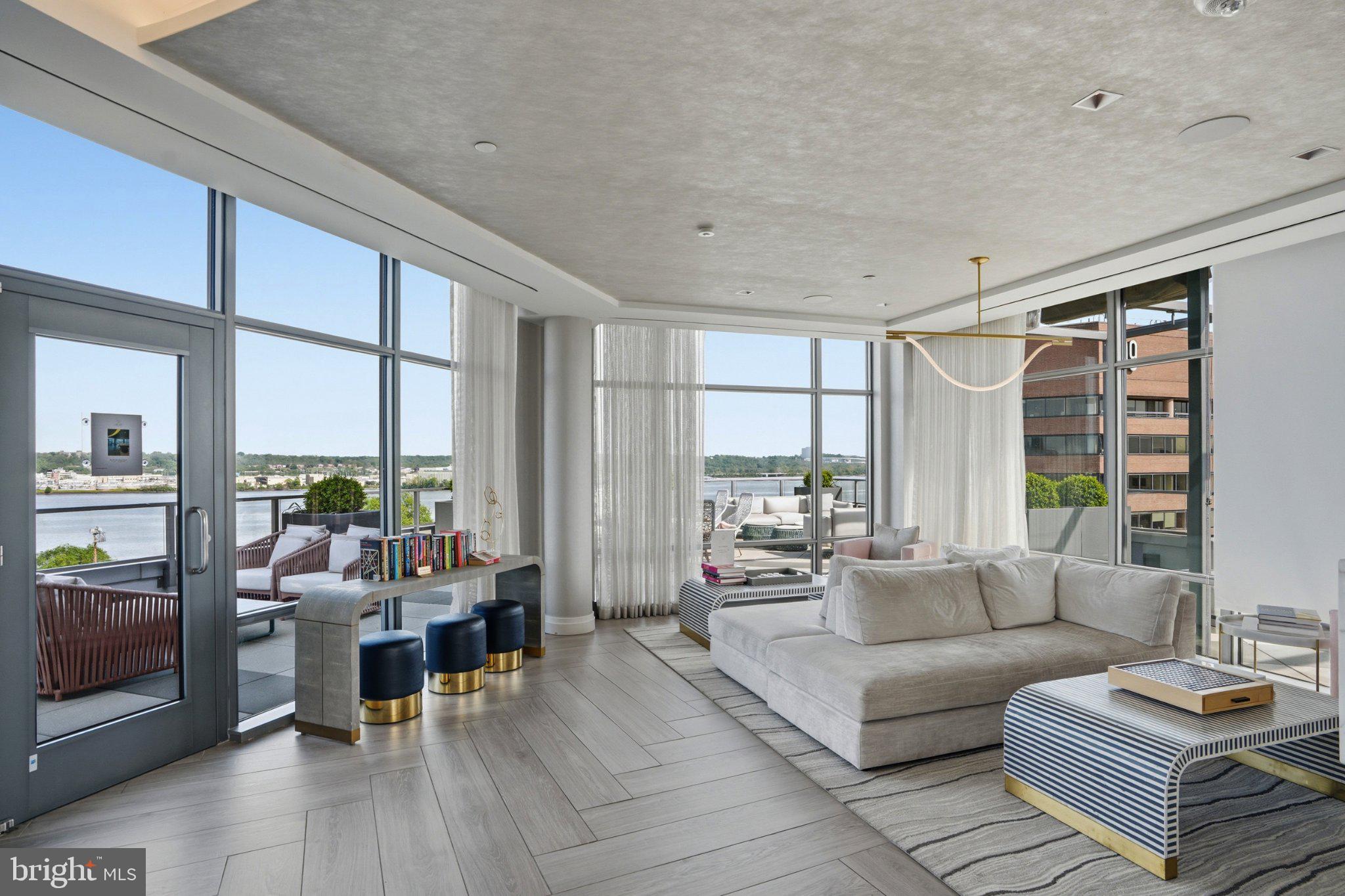 Residence 206 at the Muse is a standout offering in Old Town North, one of the most desirable waterfront neighborhoods within Old Town Alexandria, where sophisticated contemporary design, abundant natural light, and an exceptional indoor-outdoor lifestyle come together. Expansive floor-to-ceiling windows frame peaceful green space with beautiful Potomac River views, while the private balcony provides the perfect setting to enjoy morning coffee or evening sunsets.

Designed for both everyday living and effortless entertaining, the open-concept floor plan flows seamlessly between the living, dining, and kitchen spaces. The beautifully appointed kitchen features an oversized island, sleek custom cabinetry, premium appliances, and refined finishes that balance style with functionality.

The spacious primary suite serves as a private retreat with walk-through closets and a spa-inspired bath featuring dual vanities, an oversized glass-enclosed shower, and elegant finishes. Additional bedrooms provide exceptional flexibility for guests, a dedicated home office, or evolving lifestyle needs.

Residents of The Muse enjoy an exceptional collection of luxury amenities, including a rooftop terrace with sweeping Potomac River and Washington skyline views, outdoor lounge and grilling areas, a state-of-the-art fitness center, resident lounge, concierge-style lobby, secure garage parking, and private storage.

Perfectly positioned in the heart of Old Town North, this residence is moments from the Potomac River, marina, acclaimed restaurants, boutique shopping, cafés, scenic trails, and the historic charm of Old Town Alexandria. The neighborhood continues to evolve with significant public and private investment, further enhancing its appeal as one of the region’s premier waterfront destinations while preserving the walkable lifestyle residents enjoy.

Conveniently located near Reagan National Airport, Washington, DC, National Landing, and major commuter routes, Residence 206 presents a rare opportunity to own an exceptional luxury condominium where timeless design, premier amenities, and an unmatched location come together.