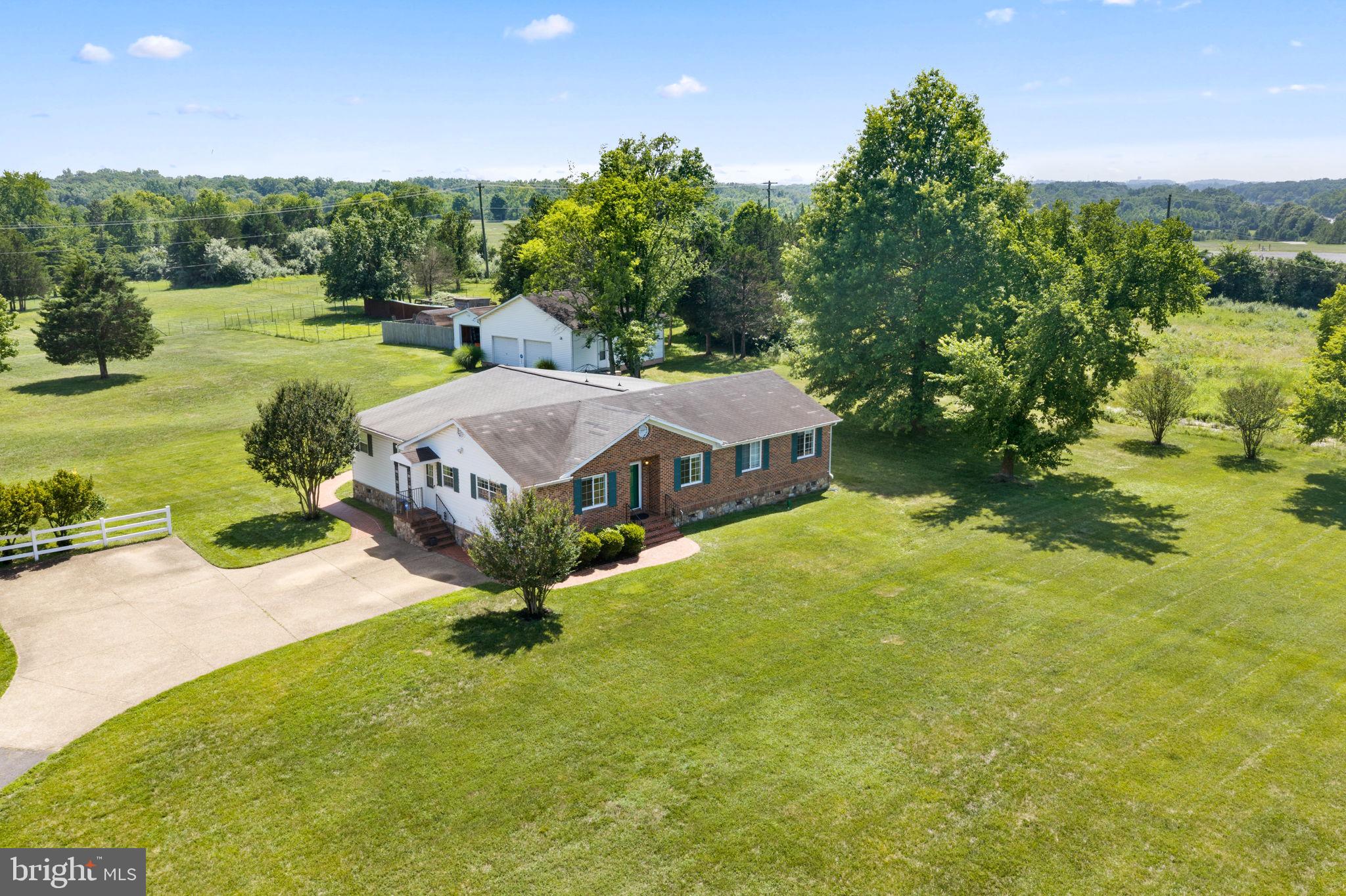 What makes this **4-bed rambler in Centreville** stand out?
Set on more than 8 private acres at 14917-A Compton Road, this beautifully maintained home offers over 2,500 square feet, flexible living areas, cleared flat land, on public water/sewer, an oversized garage/workshop, parkland surroundings, and a peaceful setting minutes from Clifton, Route 28, Route 29, and I-66.

Welcome to a lovely, owner-designed rambler where pride of ownership is clear inside and out. Thoughtfully planned and lovingly maintained by its contractor owner, this home offers space, privacy, craftsmanship, and everyday functionality in a setting that feels tucked away while still close to Northern Virginia conveniences. Inside, the layout lives larger than expected, with a spacious family room, separate rec room, formal dining room, and eat-in kitchen area. The kitchen is a true centerpiece, beautifully finished and designed for everyday cooking, hosting, and gathering. With more than 2,500 square feet of living space, 4 bedrooms, 2.5 baths, and multiple bonus rooms, the floor plan offers flexibility for work, hobbies, guests, storage, or quiet retreat space. The primary suite includes a full bathroom plus a very large sitting area  and a private office complete with a door and lock for added privacy and practicality. 

Outside, more than 8 acres of cleared, flat, usable land create extraordinary lifestyle flexibility. Gardeners can imagine raised beds, vegetable gardens, flower fields, orchard space, or hobby farming areas, while outdoor enthusiasts have room for recreation, animals, equipment, entertaining, or a future pool. 

 The property also includes an oversized two-car garage/workshop with full electricity, workshop storage, a kitchenette, and a convenient half bath, ideal for car enthusiasts, hobbyists, collectors, contractors, or anyone who needs serious workspace and a place to wash up before entering the main home. Additional outbuildings including a small rustic livestock barn or animal shelter with stall-style sections provide even more storage and functional possibilities. A chicken coop conveys and is currently home to four hens. 

Backing to parkland near Bull Run Regional Park, the property offers a beautiful sense of privacy and connection to nature, with scenic trails, outdoor recreation, the Bull Run Occoquan Trail, and the holiday Festival of Lights all part of the surrounding Centreville lifestyle. The Festival of Lights can be seen from the property during the holidays, and the owner has received complimentary tickets in prior years, though future availability should be independently verified. Near Bull Run Regional Park, historic Clifton, local wineries, Route 28, Route 29, I-66, and Centreville conveniences, this **4-bed rambler in Centreville** delivers acreage, privacy, flexible interior space, and exceptional utility.
HWH is approximately 3 years old. HVAC is approximately 7 years old.