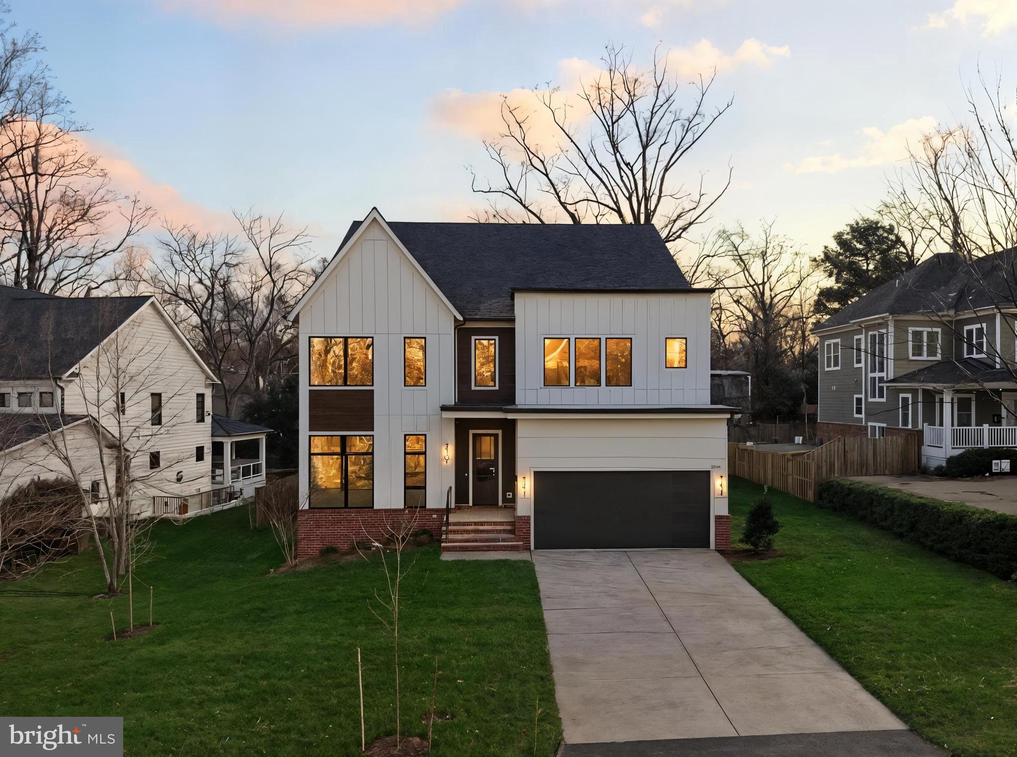 A striking expression of modern luxury in the heart of Falls Church, 2107 Greenwich Street is a move-in ready, newly built modern transitional residence by Georgetown Builders, thoughtfully designed with clean architectural lines, warm natural finishes, and exceptional craftsmanship across every level. The commanding exterior blends brick and James Hardie siding with a dramatic modern steel entry door, slate front steps, professionally designed landscaping, and a two-car front-load garage—setting a bold yet refined first impression.

Inside, the sun-filled main level offers soaring 10-foot ceilings, exquisite 8.5” wide wire-brushed white oak hardwood floors, custom oak staircases with sleek steel railings, and a stunning linear gas fireplace wrapped in oversized porcelain tile. The chef’s kitchen is both functional and show-stopping, featuring rift-cut custom cabinetry, quartz countertops with a waterfall island, floating shelves, prep sink, and a premium Z-LINE appliance suite highlighted by a 48” gas range and oversized French-door refrigerator. A spacious butler’s pantry with beverage refrigerator enhances everyday convenience and entertaining ease. Expansive glass doors connect the interior to a covered rear porch and open Trex deck, creating a seamless indoor-outdoor lifestyle overlooking a private, landscaped backyard.

The upper level continues the sense of scale with 9-foot ceilings throughout. The primary suite is a true retreat, complete with a customized dressing area, built-in walk-in closets, and a spa-inspired bath featuring a freestanding soaking tub, oversized custom shower, heated floors, LED mirrors, quartz countertops, and designer porcelain tile. Secondary bedrooms offer generous closet space, refined trim details, and beautifully appointed en-suite baths, while a large laundry room with built-in cabinetry adds everyday practicality.

The fully finished lower level expands the home’s versatility with 9-foot foundation walls, an expansive recreation area, wet prep bar with dishwasher and beverage refrigerator, exercise or media room, large finished storage space, and a private au pair or guest suite with full bath. A glass-door walk-up floods the level with natural light and provides direct outdoor access.

This residence is equipped with a comprehensive structured wiring package, multi-zone WiFi audio and surround sound, hardwired security with CCTV, abundant designer LED lighting, and premium trim and paint finishes throughout. Energy efficiency is thoughtfully addressed with dual-zone high-efficiency HVAC, WiFi thermostats, advanced insulation, humidification, and passive radon mitigation—delivering comfort, performance, and peace of mind.

Perfectly positioned on a quiet, tree-lined street in the heart of Falls Church, this home offers exceptional convenience to dining, parks, Metro access, and major commuter routes. Just minutes to Tysons Corner, Washington, DC, and both Dulles International Airport and Reagan National Airport, the location also provides easy access to Northern Virginia’s celebrated wine country, including the picturesque town of Middleburg. A rare opportunity to enjoy sophisticated new construction living with unmatched access to the region’s best destinations.