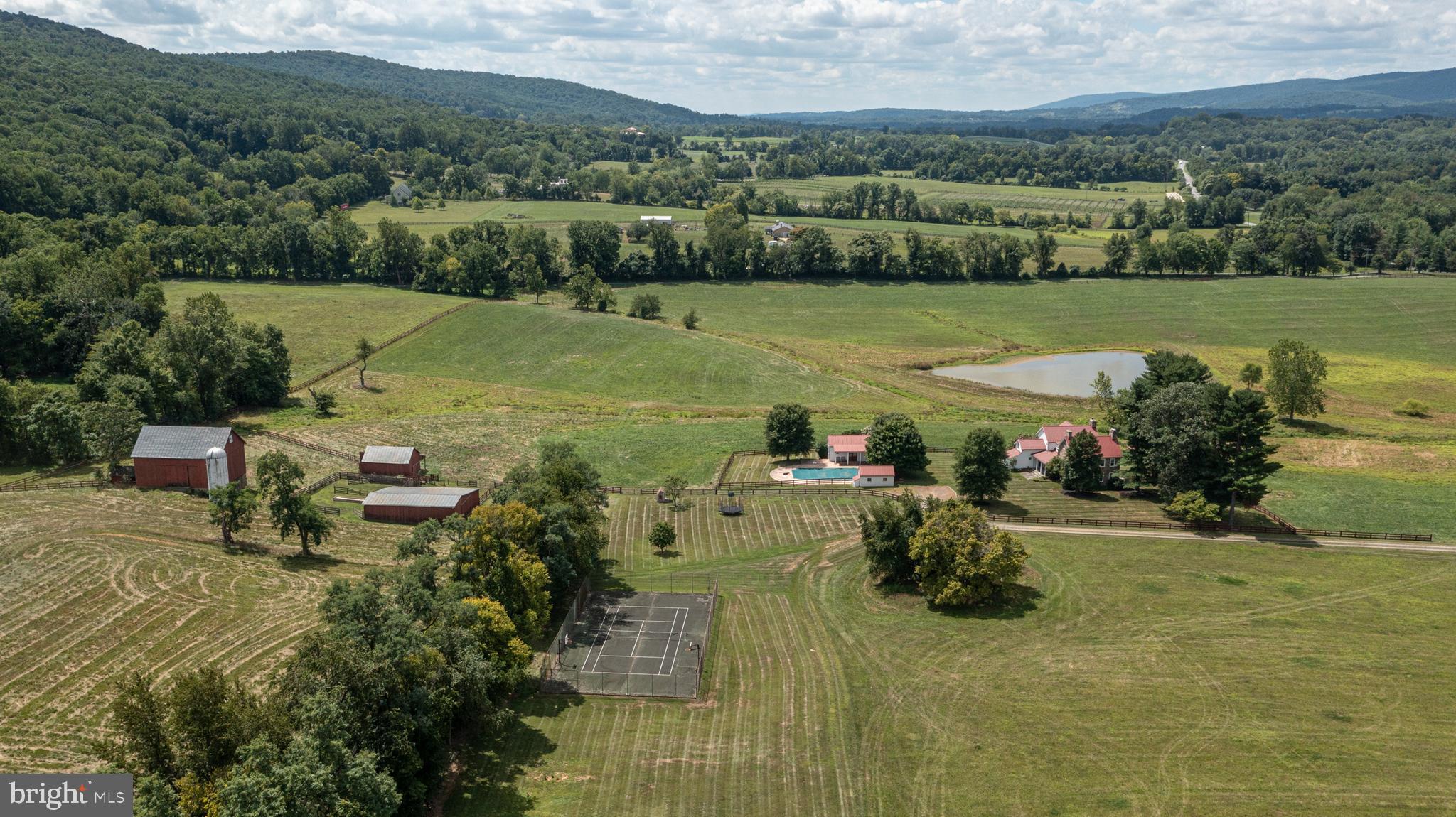Welcome to this beautiful and historic property located in the Neersville Valley between the majestic Blue Ridge and Short Hill mountains. An admired US Secretary of State owned this property with family members for nearly fifty years as a weekend home and working farm. The peaceful and private get-a-way property encompasses 361 panoramic acres, a primary home, two auxiliary homes (each with  three bedrooms), two spring-fed ponds, bank barn, machine shed and multiple run-in sheds. The original stone home dates back to 1792 and has been tastefully renovated to preserve the historic features of the era. The home has an aesthetically appealing, architecturally designed addition providing a large family room, rec room, and multiple bedrooms and bathrooms.
  
The home is in pristine condition and features a true chef’s kitchen with a Viking 6 burner range and grill, Subzero refrigerator, double wall oven, built-in microwave, large island and granite countertops. The kitchen flows into a large light-filled family room with a stone fireplace and built-in bookshelves - which is great for family fun and entertaining. There are three large French doors in the family room that open onto the large screened-in porch that overlooks a pond, pasture fields and mountains. The main level also includes two parlors with fireplaces, a full bathroom, a large mudroom and a spacious laundry room with a wash sink and built-in cabinets.

On the upper level there are 6 beautiful bedrooms, 2 full bathrooms and a sun-filled sitting area with bookshelves. This historic home has antique pine floors, built-in china cabinet, hand-crafted banisters, antique hardware, five fireplaces and two stairways.

This property is further complemented by a tennis court, swimming pool, and pool house with a bathroom, game room, and kitchen. This historic site is located on a large parcel of rolling land in a much sought-after part of Virginia, yet within easy reach of our nation’s capital. The Neersville Valley is rapidly becoming well-known for vineyards, wineries, breweries, farm-to-table dining options and weekend getaways. The property is also in close proximity to the hiking trails of the Appalachian Trail and the historic sites of Harpers Ferry National Park and Antietam Battlefield. This is an excellent opportunity for someone looking to start their own upscale winery and event center or private retreat. This 361-acre magnificent property is currently divided into 16 parcels which also makes for a great investment or family compound.