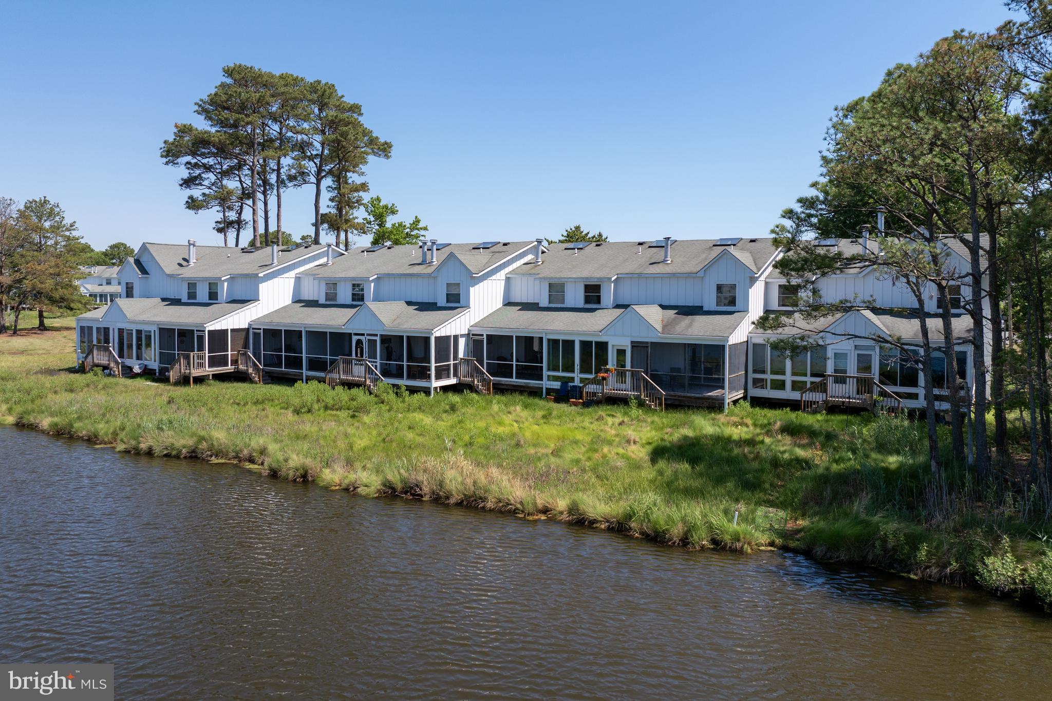 Welcome to this comfortable 2-bedroom coastal residence in the coveted area of Mallard Lakes. Located just 2.5 miles from the beach and within walking distance to local shopping and restaurants, this home offers an ideal balance of convenience and tranquil vacation living.  Even before entering this beautiful home, you will be impressed by the lush, mature greenery and several outdoor features including an outdoor shower and a private storage unit for keeping your beach gear and other items. Step inside, and you will be greeted by a bright, well-equipped kitchen complete with a large island breakfast bar and modern granite countertops - perfect for socializing with friends while enjoying a good meal. Adjacent to the kitchen is a half bathroom for your convenience, as well as a discreetly situated laundry area. The dining space seamlessly transitions into a large living area complete with entertainment center accompanied by a large screen TV.  You'll be captivated with its stunning lake views - an ideal spot for unwinding, sipping on your morning coffee, and watching the local wildlife. The second level features two large bedrooms that both have access to a spacious full bathroom, featuring double sinks and a shower / tub combo. The primary suite enjoys amazing lake views. As part of the Mallard Lakes community, residents have access to an array of first-rate amenities including basketball courts, a community beach, picnic areas, a pier, multiple swimming pools, pickle ball and tennis courts, play areas for the little ones, and volleyball courts. Make this rare & affordable beach home yours today!
