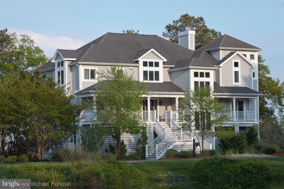 Custom designed waterfront home with only the best of appointments and finishes awaits you.  This home is located in the lovely waterfront community of Ocean Reef in the West Ocean City area. Privacy and comfort abound, yet you are only minutes to the beach and Ocean City. Spectacular views of Sinepuxtent Bay, Assateaque Island, wildlife and the Atlantic Ocean create the picture perfect setting.  Walk out your back door to you pier and dock with private boat lift.  There is ample space for an outdoor pool & outdoor dining area.  Renderings for your future outdoor oasis are available online.When approaching this magnificent home you will be greeted with a circular driveway in a serene environment.