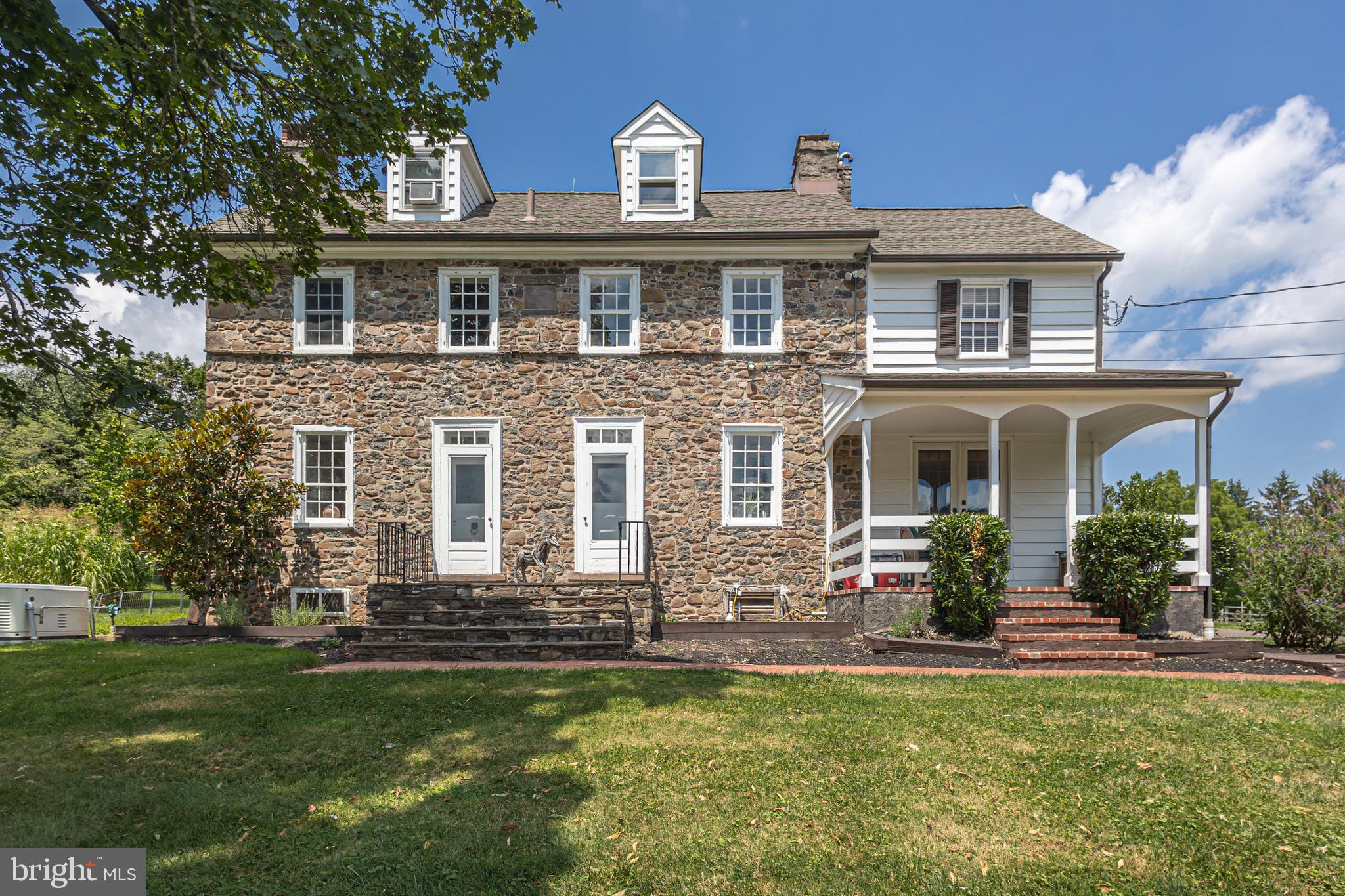 Flower Farm offers a rare blend of history and charm on a  5.25 acre parcel in picturesque Upper Makefield Township.   At its heart lies a distinguished 1795 stone farmhouse, gracefully complemented by a separate in-law/guest cottage,  and equestrian potential with a five-stall horse barn. The main residence showcases wood flooring throughout the first level, where timeless elegance meets everyday functionality. A formal living room and family room, each with their own fireplace, flank the foyer. The formal dining room—perfect for entertaining—features exposed stone walls and French doors that open to a brick floored screened porch perfect for enjoying informal family gatherings or a morning cup of coffee.  The spacious kitchen with its stainless steel appliances , newly installed granite countertops and thoughtfully designed layout invite intimate gatherings.   Also, on the first floor is a flex room (study or bedroom) along with a full bath.   Upstairs, the second floor offers a serene primary suite, two additional bedrooms, additional space for a  home office and a walk-up third floor attic, ready for thoughtful updates. Step outside onto a covered porch, breezeway, and vine-draped pergola, that seamlessly connects to the adjacent guest cottage.  This charming in-law/guest cottage boasts its own eat-in kitchen, cozy living room with fireplace, first-floor bedroom and full bath, and hardwood floors throughout. The second level provides a private suite complete with a full bath and walk-in closet. Perfectly suited for a multi-generational family compound or weekend retreat, this charming  property offers peace and privacy, yet remains just 90 minutes from New York City, 50 minutes from Philadelphia, and 30 minutes from Princeton.