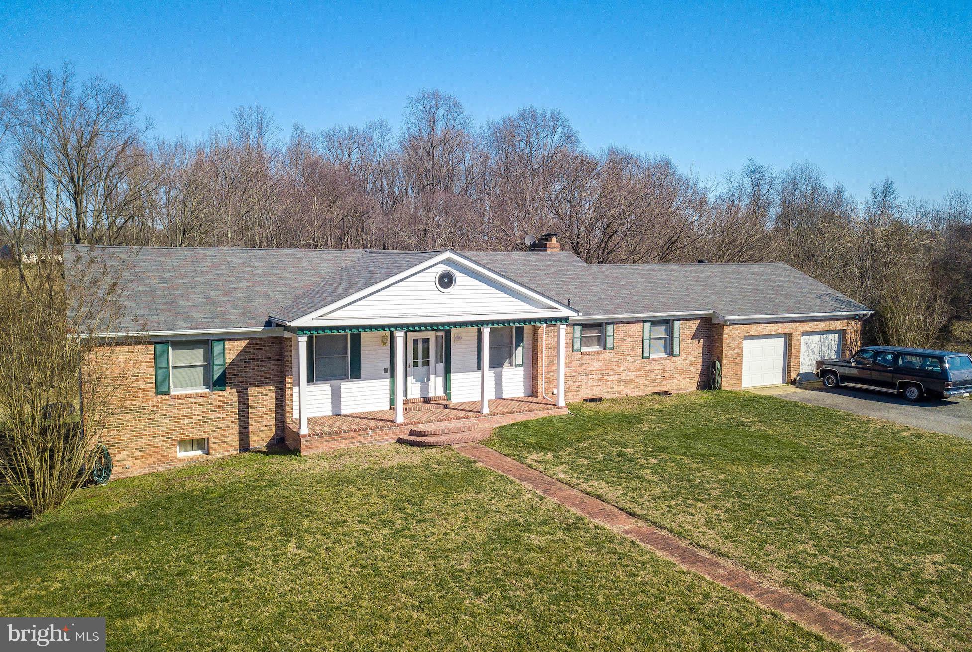 WOW! 14 Acres, Great Setting, All Brick Rambler, In Law Suite, Privacy,  THIS PLACE has it all.   This place will make you feel relaxed and cozy!  You have so much room to spread out! Home has been very well kept.   Main Floor offers  Large Eat In  Kitchen with Pantry, Large Living Room and Family Room, 3 Bedrooms, 2.5 Baths, Laundry Room.  The lower level offers a full In Law Suite with LR, DR/Kitchen Combo Area with Pellet stove, Bedroom/Office, Bedroom/Game Room, Storage Area, Laundry Room, New Carpet and Rear Exit.  In addition to the 2 car attached Garage, there is an outbuilding/garage area with electric and water and shed attached to it.  There is a metal carport cover for extra storage.   In the Spring, the driveway is lined with blooming trees and green all summer long.  Enjoy walks in the wooded area to a small pond, Nature at its best.  The 3.16 acre outparcel is part of this property which gives it the 14 acres.    There is so much to offer here.  Too Much to list!  Don't Miss Out on this one!