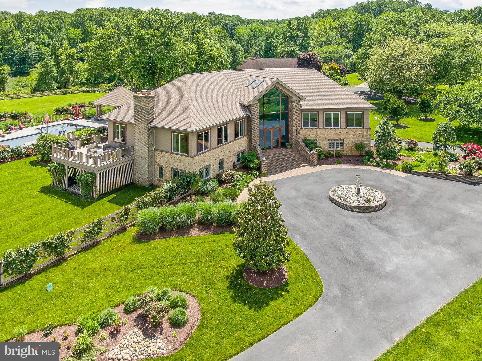 Welcome to 6975 Kim Lane, a stunning home set in the esteemed Chesapeake Overlook community. This community features a private beach and is just minutes to the award-winning Herrington Harbour South Marina. Offering an unparalleled blend of luxury and coastal charm, this property boasts panoramic views of the Chesapeake Bay and offers an exceptional blend of luxury and charm - a true testament to meticulous design and thoughtful craftsmanship. As you enter through the custom-imported German front door, you’re greeted by a grand foyer adorned with a stunning custom chandelier. A split staircase ahead leads to an inviting sitting area filled with natural light, offering a warm welcome into the home’s refined elegance. Ten-foot ceilings with intricate crown molding and gleaming Italian ceramic tile floors create a sense of openness and sophistication throughout this home. The gourmet kitchen with custom cabinets and exotic granite countertops is a showstopper. Anchored by a large island with seating for four and equipped with Viking Professional appliances (a 6-burner gas cooktop with griddle, built-in refrigerator and freezer, steamer, double ovens, pot filler, trash compactor, a second sink, and separate ice maker), you'll notice that no detail has been spared in the design of this area. A butler’s pantry adds even more function with a beverage cooler, sink, and abundant cabinetry. The formal dining room features a custom granite dining table ideal for gatherings of any size. The spacious, grand living room features a gas fireplace, custom built-ins, and expansive windows that flood this space with natural light and showcase stunning water views. Sliding doors lead to the deck—perfect for unwinding or hosting with the Bay as your backdrop. This main level also features a spacious primary suite designed for comfort and indulgence, complete with a private sitting area overlooking the Bay, two walk-in closets and a spa-inspired bath with heated floors, dual vanities, a jetted soaking tub and a large walk-in shower. A second bedroom on this level also includes a walk-in closet and private en-suite bath, ideal for guests or family. The lower level offers a seamless blend of function and luxury. From the oversized two-car garage with abundant storage, step directly into a spectacular wine cellar and cigar lounge—perfect for relaxing or entertaining with style. This level also includes two private offices, both with access to the stone patio and garden, a large third bedroom with a spacious closet, the laundry room and a versatile room that can serve as a 4th bedroom or a home gym, complete with a sauna. The large recreation room features a second fireplace, a full wet bar with seating, and sliding doors leading to the meticulously landscaped grounds. The fully fenced backyard is a private resort featuring a heated pool, a flagstone patio, gazebo and a full outdoor kitchen with a TV and dining area. Raised garden beds, a basketball area, and lush landscaping with an irrigation system. The DETACHED, OVERSIZED TWO CAR GARAGE features a guest suite with a  bedroom and full bath, for those seeking privacy and separate living, in addition to an expansive 1,762 sq ft garage or workshop complete this stunning and unique property! This exclusive community is celebrated for its serenity and prime location. The Herrington Harbour offers protected boat slips, a private beach, an Olympic-size pool, fitness center, tennis and pickleball courts, playgrounds, and some of the best waterfront dining in the region at Ketch 22. With seasonal events, beach bonfires, kayaking and the scenic Chesapeake Rail Trail just minutes away, this location delivers a rare blend of coastal charm, natural beauty and lifestyle convenience—a short drive to DC, Annapolis and Virginia.  This one-of-a-kind property is more than a home—it’s a lifestyle.