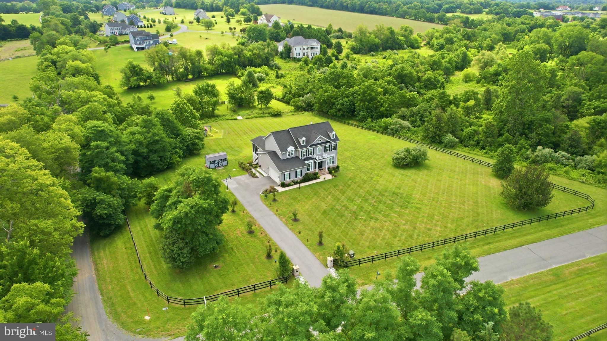 ✨ Welcome to 12720 Snowbird Court—an exceptional luxury residence in Eagle Creek Estates featuring the highly sought-after Chestnut Grove model by Carrington Homes. 🏡 Set on a premium three-acre lot with no HOA, this coveted estate home offers more than 5,000 finished square feet, five spacious bedrooms, four full bathrooms, and one half bath. Built in 2020, the home showcases exceptional finishes and more than $250,000 in post-closing improvements, including surround sound, a screened-in porch, Trex deck, flagstone patio, and fully fenced backyard.
🌄 Set against the scenic backdrop of the Short Hill Mountains and Milltown Creek, which runs along the rear of the property, this extraordinary setting offers a rare combination of tranquility and privacy. Illuminated stone piers welcome guests at the foot of the private driveway, while the expansive grounds offer endless possibilities—envision a resort-style pool, additional garage or living space, or the outdoor retreat you have always imagined.
🚪 Signature Carrington mahogany front doors open to a dramatic foyer highlighted by custom arched openings, an oak staircase, and hardwood flooring throughout the main level. The open and expansive floor plan is filled with natural light and elevated by impressive 10-foot ceilings, a coffered family room ceiling, and extensive dentil and crown molding.
🍽️ At the heart of the home is the gourmet chef’s kitchen, centered around an extended 9-foot quartz island with accented cabinetry on both sides. White and gray designer cabinetry, a stylish backsplash, stainless steel appliances, farmhouse sink, custom vent hood, gas cooktop, and double wall ovens complete the space. An additional wall of cabinetry creates the perfect coffee bar or butler’s pantry, while a planning desk adds sophisticated functionality. The extended breakfast nook opens through French doors to the covered and screened-in porch.
🔥 A spacious walk-in pantry and mudroom with custom built-in cubbies provide convenient everyday entry from the side-load garage. Arched openings lead to the adjoining family room featuring a gas fireplace with custom TV cabinetry and a wall of windows framing the private landscape. An art gallery-style arched hallway leads to the beautifully appointed formal dining room. A private home office with plantation shutters, flexible bonus room ideal for a second office or study, and powder room complete the main level.
🛏️ Upstairs, hardwood flooring continues through the spacious landing. The luxurious primary suite features updated wide-plank flooring, a tray ceiling, designer lighting, dual walk-in closets, and a spa-inspired bath with soaking tub, separate vanities, walk-in shower, and herringbone-patterned tile. The second bedroom offers a private en-suite bath, while bedrooms three and four share a Jack-and-Jill bath. An upper-level laundry room adds convenience.
🎬 The fully finished walkout lower level features wide-plank flooring and abundant natural light. A fifth bedroom with a stylish barn door and full bath provides an ideal private space for guests or extended family. The spacious recreation room features an electric fireplace, wet bar rough-in, and French doors opening to the stone patio. A dedicated media room with a second electric fireplace creates the ultimate movie-night experience, with media equipment and theater chairs conveying.
🌿 Outdoor living is equally impressive. A custom arched flagstone patio, generously sized Trex deck, and screened-in porch create multiple inviting spaces for entertaining and relaxation. Substantial stone pillars frame the covered patio below the deck. Additional storage beneath the screened-in porch and a large storage shed provide ample space for outdoor equipment.
📍 Ideally located minutes from downtown Lovettsville, owners enjoy easy access to charming shops, restaurants, the new Co-Op grocery store, and Lovettsville Community Park.