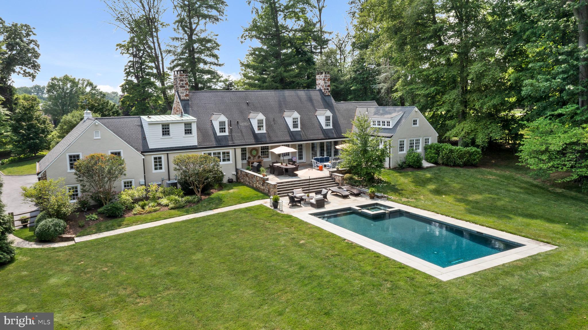 Serene elegance abounds from the moment you arrive at 276 Abrahams Lane, as this historic  gem immediately captures your heart and exudes quality and sophisticated living.  Originally part of the Ardrossan estate, this magnificent 2 acre property quietly blends into its surroundings and has long been admired by many. Nestled amongst mature landscaping, this home embodies refined living and designed for those who appreciate a lifestyle of understated elegance and comfort. Years of meticulous redesign and updates have elevated this estate to a rare level of luxury and sophistication. Gleaming hardwood floors seamlessly connect  the eloquent  First Floor where formal and informal spaces harmoniously blend together, creating an open floor plan to be enjoyed daily and entertained in often. Understated elegance abounds and this custom home was  masterfully created to capture the backyards majestic setting that will take your breath away. The stunning  craftmanship can be felt room to room with an abundance of luxurious features that set it into a class of its own. Both the gracious Living and Dining Rooms feature deep windowsills and fireplaces, artfully blending  into the  gourmet Kitchen, Breakfast  and Sitting Areas. A true chefs delight the Kitchen is highlighted by a massive teak island, brick Aga stove with custom metal hood, Miele refrigerator armoire and so much more.  A lovely custom banquette provides a cozy seating area with stunning display cabinetry  flowing  into the adjoining Sitting Area with  entertainment center. The warmth of the home continues up to into the vaulted Family Room with lacquered paneled  walls providing the perfect venue for movie/tv viewing. On the opposite side of the home the most heavenly First Floor Primary Suite awaits offering a private sanctuary of comfort and luxury.  It features vaulted ceilings with rustic beams that enhance the spaciousness of the room, while walls of windows flood the space with natural light and offer  tranquil views of the lush  backyard oasis.  French doors lead directly from the suite to the Patio, perfect for easy access to your private outdoor retreat. A spa like Primary  Bath with deep soaking tub, double vanities and walk-in shower gracefully connects into the most fabulous custom his and her Dressing Rooms, designed with exceptional built-ins, ensuring all clothing and accessories are neatly organized and accessible. The First Floor is completed by a lovely Powder Room and a gracious staircase leads to the Second Floor where three en-suite Bedrooms can be found. Each suite features exceptional Bathrooms and outfitted closets with a  Second Floor landing providing  the perfect area to relax and  read a book. The Lower Level offers an additional 1,235sq ft  of finished family friendly space with  a sliding barn door that opens to a brand new Full Bath. The Lower Level is completed by a Laundry Room, Storage Room, and  Mudroom conveniently located off of the 2 car attached Garage. The magic continues outside where flagstone tired terraces gracefully lead to the newly built salt water pool creating an exquisite centerpiece that seamlessly blends into a carpet of grass. For all sports enthusiasts, a small portion of the backyard has turf out of respect respect not to disturb the backyard oasis.  Don't miss your opportunity to own 276 Abrahams Lane, which not just a residence but a prized jewel  in the heart of Radnor Townships  Ardrossans  neighborhood.