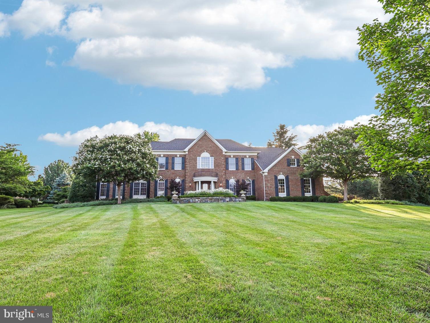 Freshly painted custom estate with a 3-car garage, offering an incredible combination of luxury, craftsmanship, and resort-style living on one of the largest premium lots in Belmont. 
***
A grand marble foyer welcomes you into an elegant interior highlighted by wide-plank hardwood flooring, custom millwork, detailed decorative finishes, wrought iron stair balusters, and abundant natural light. The thoughtfully expanded floor plan includes multiple custom additions that significantly enhance the home's size, functionality, and appeal.
***
At the heart of the home is a spectacular chef's kitchen featuring premium Viking and Sub-Zero appliances, a six-burner range with pot filler, Advantium double wall ovens, custom cabinetry, stone countertops, and exceptional workspace. The adjoining sunroom addition creates the perfect gathering space with a cozy gas fireplace and picturesque views of the outdoor retreat.
***
The expansive family room features slate flooring, custom built-ins, a gas fireplace, and ample space for entertaining. A richly appointed main-level library with built-in shelving offers the ideal home office or study, while the impressive conservatory addition is surrounded by walls of windows that flood the home with natural light. The formal dining room showcases custom moldings, a tray ceiling, and a butler's pantry complete with wine cooler.
***
The luxurious primary suite is a true private retreat featuring a coffered ceiling, gas fireplace, spacious sitting room, expanded custom closet space, and a spa-inspired bath with heated tile floors, elegant columns, illuminated dome ceiling, oversized shower, and premium finishes throughout.
***
Extensive additions include a three-story expansion creating additional space for the conservatory, golf simulator room, and expanded primary suite closet; a two-story addition adding the sunroom and card room; and a separate two-story addition incorporating an oversized laundry room and additional finished lower-level living space with full bath.
***
The fully finished lower level offers an incredible entertainment experience with a massive recreation room, dedicated theater area featuring a 4K digital projector and Polk Audio sound system, custom wet bar, game room, card room, exercise room, golf simulator room, workshop, den/guest bedroom, two full bathrooms, and abundant storage. All installed audio/visual equipment conveys, including multiple televisions, projectors, speakers, and entertainment systems.
***
Outdoor living is equally impressive. The nearly one-acre homesite has been transformed into a private natural stone oasis featuring extensive hardscaping, a tranquil stream, koi pond, outdoor stone fireplace, built-in stone cooking and grilling area, jacuzzi, mature landscaping, irrigation system, and multiple gathering spaces designed for year-round enjoyment. The setting offers exceptional privacy and one of the largest lots in Belmont.
***
Additional highlights include three gas fireplaces, custom window treatments throughout, epoxy-coated garage flooring, upgraded lighting and fixtures, extensive technology enhancements, and countless custom details rarely found in today's market.
***
Residents of Belmont Country Club enjoy exceptional amenities including Arnold Palmer Signature golf course, modern fitness center with classes, 7 tennis courts, and pickleball, three swimming pools, upscale dining at Lee's Table & Tavern, and year-round social events and community activities. The HOA also provides lawn care, trash and recycling, high-speed internet, and cable TV, making homeownership easy and low maintenance. Prime Loudoun County location convenient access to: Washington Dulles International Airport, Belmont Chase shopping, and dining. One Loudoun lifestyle center and Lansdowne Town Center. With nearby access to the Silver Line Metro and major commuter routes, this location blends luxury living with everyday convenience.