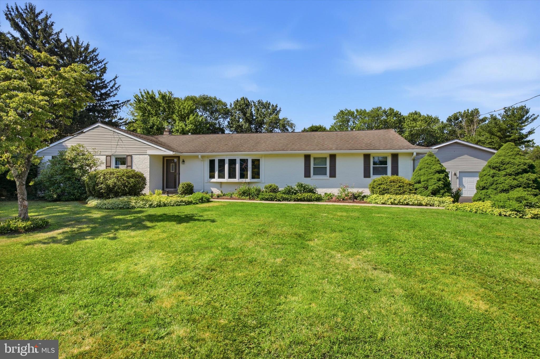 Set on a picturesque one acre lot in desirable Upper Gwynedd Township and within the award winning North Penn School District, this sprawling ranch offers the perfect blend of comfortable everyday living and exceptional entertaining space. The thoughtfully designed layout features four bedrooms, including a spacious primary suite with a spa inspired bath, two walk in closets, gas fireplace, direct access to the pool and exterior ramp access from the pool patio. Two additional bedrooms are located within the primary bedroom hall and share a full hall bath. In addition, the home offers a private flex room on the main level, currently used as a gym, that could easily serve as a home office, guest room, playroom, or hobby space. The updated eat in kitchen features granite countertops, tile backsplash, hardwood floors, a center island, and opens to the backyard, making it the heart of the home. A formal dining room, expansive great room with a wood burning fireplace and wet bar, sunny three season room, and detached four car garage provide exceptional space for everyday living and entertaining. The finished lower level expands the home's versatility with a large recreation area, a full bath, and two additional finished rooms, including one with egress that is currently set up as a bedroom, offering flexible space for guests, multigenerational living, a home office, or hobbies. Outside, enjoy summers by the fenced pool surrounded by beautiful hardscaping and mature landscaping, with additional open space for gardening or recreation. The large paved area behind the detached garage offers endless possibilities for pickleball, basketball, on your own private sports court.  Offering the best of both worlds, this home combines the privacy of a one acre lot with a convenient location just minutes from Merck, Gwynedd Mercy University, downtown North Wales and Lansdale, shopping, dining, SEPTA Regional Rail, and major commuter routes.