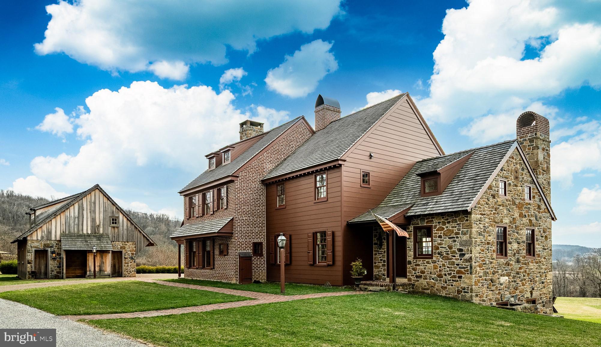 A Lacanche range handmade in France took longer to arrive than the original section of this home took to build. That singular detail reveals everything about “The Inn” at 202 Privet Lane — located in Olde Bulltown Village, an exquisitely crafted reproduction period estate set on .44 acres along the private fairways of French Creek Golf Club, masterfully designed by world-renowned architect Gil Hanse.
Conceived in 2019 and thoughtfully expanded in 2022, this 3,993 SF residence was born of an obsessive reverence for early American craftsmanship without the compromise of a single modern comfort. A sweeping gravel motor court gives way to handmade brick, locally quarried Elverson iron-stone fieldstone with its rare blue iron veining, glowing Bevolo gas lanterns, and a wooden herringbone front door.
The first floor unfolds as a complete world unto itself. Five custom mudroom lockers over real kiln-fired brick floors set the tone immediately. The coffered and beamed living room with an oversized brick and plaster fireplace and golf course views through every window follows — then a deep navy butler's pantry complete with pin oak counters from a tree sourced from the land at Bulltown, a Shaw’s Original farmhouse sink, oven, wine chiller, and Subzero refrigerator and freezer drawers, perfectly designed for hosting gatherings. The kitchen proper is in a category of its own and at the heart of the house: British Green Lacanche range commands the room with both gas and electric ovens, honed soapstone on every surface, a hand-forged iron refrigerator pull and custom hardware including rat-tail hinges. A reclaimed mill beam marks the passage into a soaring cathedral dining room with a full interior Elverson fieldstone wall, 18-arm iron chandelier, Rumford fireplace, and a 12-foot table handcrafted from reclaimed 18th-century Chester County floorboards. Distressed random-width pine floors with flathead nails and bespoke hand-crafted hardware throughout the home. A private first-floor office — wrapped entirely in a hand-painted Rufus Porter-style mural by artist Susan Leach, rolling Pennsylvania countryside on every wall — doubles as a bedroom with its own full bath and freestanding clawfoot soaking tub.
Upstairs: a primary suite with a cast-iron gas potbelly stove, walk-in closet, and floor-to-ceiling kiln-fired brick shower with soapstone floor and rain head unlike anything else in Chester County. Two additional generous bedrooms; a secret play nook under the stairs; and a full hall bath with a reclaimed timber post rising from the vanity. The third-floor office/bedroom includes a full bath outfitted in Restoration Hardware fixtures, and Calacatta marble vanity, frames panoramic fairway views. The finished walkout lower level delivers a timeless designed family room with a Rumford fireplace, private guest suite, and full bath with hand-hammered copper sink and soapstone shower tiles. 
Outside, four levels of living unfold beneath a Chester County sky: cedar shake roof, a copper-covered timber deck off the dining room with built-in outdoor heater, unobstructed fairway views; a brick patio at the walkout level with Pennsylvania bluestone bench seating built into the fieldstone retaining walls; and a fire kettle sourced from Sea Island Forge sits upon the open lawn. French Creek Golf Club borders the property directly, while Stonewall Golf Club — home to two Tom Doak championship courses ranked among the finest in Pennsylvania — sits immediately across the road. And every evening, the western sky ignites over the rolling hills in a sunset that stops you mid-sentence. Situated just 45 minutes from Philadelphia.
Detached 2-car carriage house (672 SF + 486 SF above, fully wired, plumbed, internet-cabled, and wired for electric vehicles). 5-zone geothermal HVAC, Generac whole-home generator. Radon mitigation in place. HOA ($3,325/yr) maintains lawn, snow, and trash. Built to endure for centuries. Ready for you today.