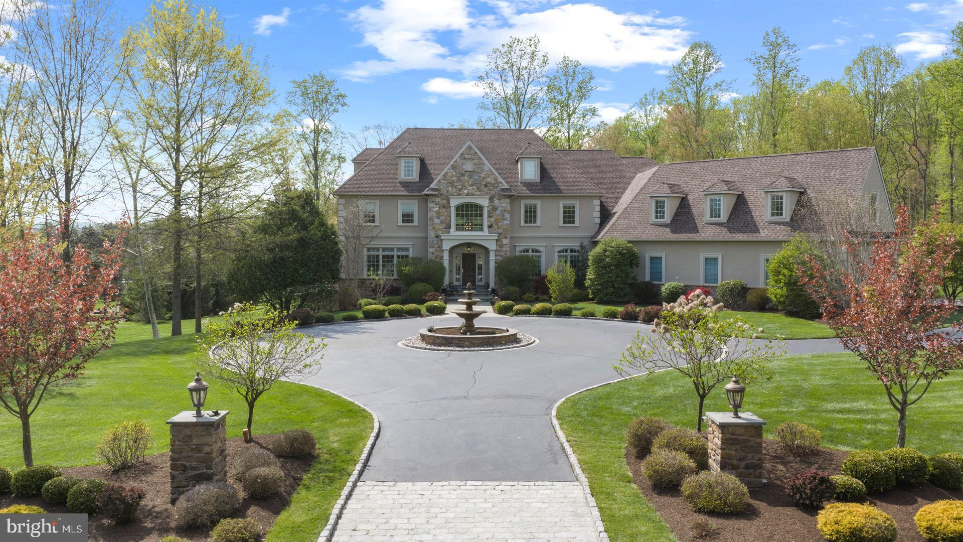 Experience exceptional luxury on 4+ acres in one of Solebury Township’s most coveted enclaves. Ideally positioned on a cul-de-sac, this custom-built Bucks County estate offers a rare combination of acreage, privacy, and architectural presence—introduced by a stately circular drive and fountain that set the tone for what lies beyond.

Step into the marble foyer with a gorgeous curved staircase and premium trim work.  Designed with both everyday living and elevated entertaining in mind, the chef’s kitchen features radiant heated floors, professional-grade stainless appliances, expansive granite surfaces, and an oversized center island with secondary dishwasher and refrigerated drawers. The dramatic 20+ foot high coffered family room is anchored by a stone wood-burning fireplace and framed by walls of windows overlooking a serene lawn and beautiful treed meadow beyond. Formal living room with gas fireplace, formal dining room, a butler’s pantry complete with wet bar, and a private office featuring custom built-ins and access to a wrap-around covered porch complete the main level.

Upstairs, the primary suite offers a true sense of retreat, with a spacious sitting area, dual walk-in closets, tray ceilings, and a separate flex space ideal for a custom walk-in closet, gym, or perhaps a large second floor laundry room. The spa-inspired bath features a steam shower, jetted soaking tub, dual vanities, and radiant heated floors. Three additional ensuite bedrooms and a full third-floor princess suite provide comfort and privacy for family and guests.

The finished lower level is thoughtfully designed for entertainment, featuring a pub-style bar, gaming area, a dedicated home theater with projection and surround sound, along with another bonus room, a full bath, and a large workshop. And its wall of windows and connection to the backyard do not disappoint.

Outdoors, the 4.25 acres offer endless potential, with ample space for a future pool and outdoor kitchen, complemented by patios and a wrap-around covered porch. Additional amenities include a generator, an alarm system, and a heated 4+ car garage with premium SwissTraxx flooring, many cabinets and shelves, and stairs leading directly to the basement.

Located within the award-winning New Hope–Solebury School District and just minutes from the vibrant rivertowns of New Hope and Lambertville—with convenient access to New York, New Jersey, and Philadelphia—this property represents a rare opportunity to own a private estate of this scale and caliber in the heart of Bucks County.