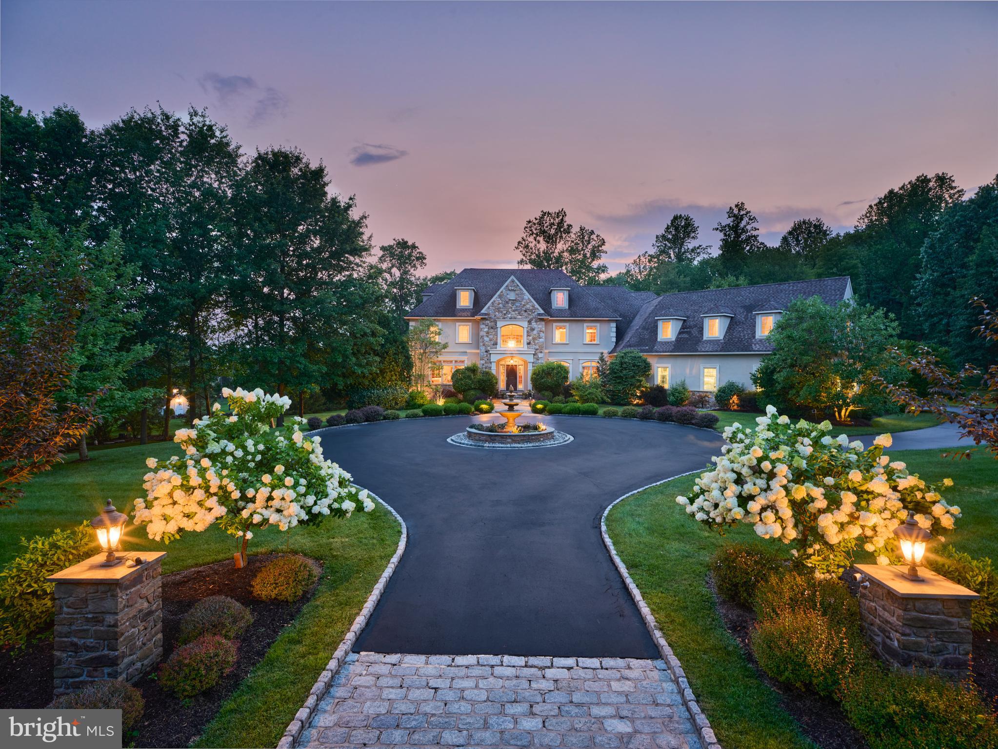 MULTI-GENERATIONAL LIVING • TWO PRIVATE GUEST/NANNY/IN-LAW SUITE OPPORTUNITIES • 4.25 ACRES • AWARD-WINNING NEW HOPE-SOLEBURY SCHOOLS• HEATED 4-CAR GARAGE

Experience exceptional luxury on 4+ acres in one of Solebury Township's most coveted enclaves. Ideally positioned on a quiet cul-de-sac, this custom-built Bucks County estate offers a rare combination of acreage, privacy, and architectural presence—introduced by a stately circular drive and fountain that set the tone for what lies beyond.

Step into the marble foyer featuring a stunning curved staircase and exquisite custom millwork. Designed for both everyday living and sophisticated entertaining, the chef's kitchen offers radiant heated floors, professional-grade stainless Wolf gas range, two paneled dishwashers, paneled Sub-Zero refrigerator and two refrigerated drawers, expansive granite surfaces, and an oversized center island. The dramatic 20+ foot coffered family room is anchored by a  stone fireplace and framed by walls of windows overlooking the expansive lawn and picturesque treed meadow beyond. A formal sitting room with gas fireplace, elegant dining room, butler's pantry with wet bar, and a private office with custom built-ins and access to the wrap-around covered porch complete the main level.

Upstairs, the luxurious primary suite offers a true retreat with a separate sitting area, two walk-in closets, tray ceiling, and a separate flex room ideal as a custom dressing room, fitness studio, second private office, or second-floor laundry. The spa-inspired bath features a steam shower, jetted soaking tub, dual vanities, and radiant heated floors. Three additional ensuite bedrooms complete the second floor.  A private third-floor suite with its own full bath—perfect for a nanny, au pair, in-laws, adult children, long-term guests, or multigenerational living.

The finished walkout lower level is thoughtfully designed for entertaining, featuring a custom bar with fridge, sink, and clear ice machine, a gaming area, and dedicated home theater with projection and surround sound. A second private bonus room adjacent to a full bath provides another exceptional opportunity for guest accommodations, an in-law or nanny suite, multi-generational living, a fitness room, or a private home office. A large unfinished workshop offers abundant storage/hobby space and stairs leading up to the garage.  A wall of windows and French doors create a seamless connection to the covered patio and backyard.

Outdoors, the 4.25-acre setting offers endless possibilities, with ample room for a future pool, pool house, and outdoor kitchen, complemented by patios and a wrap-around covered porch. Additional amenities include a whole-house generator, security system, and a heated 4+ car garage featuring premium SwissTrax flooring, extensive cabinetry and shelving, and interior stairs leading directly to the lower level. It is equipped with central vaccuum and de-ionizer for washing your car.

Located within the award-winning New Hope–Solebury School District and just minutes from the vibrant river towns of New Hope and Lambertville—with convenient access to New York City, Princeton, Nj area, , and Philadelphia—this remarkable estate presents a rare opportunity to own a private property of exceptional scale, flexibility, and enduring quality in the heart of Bucks County.