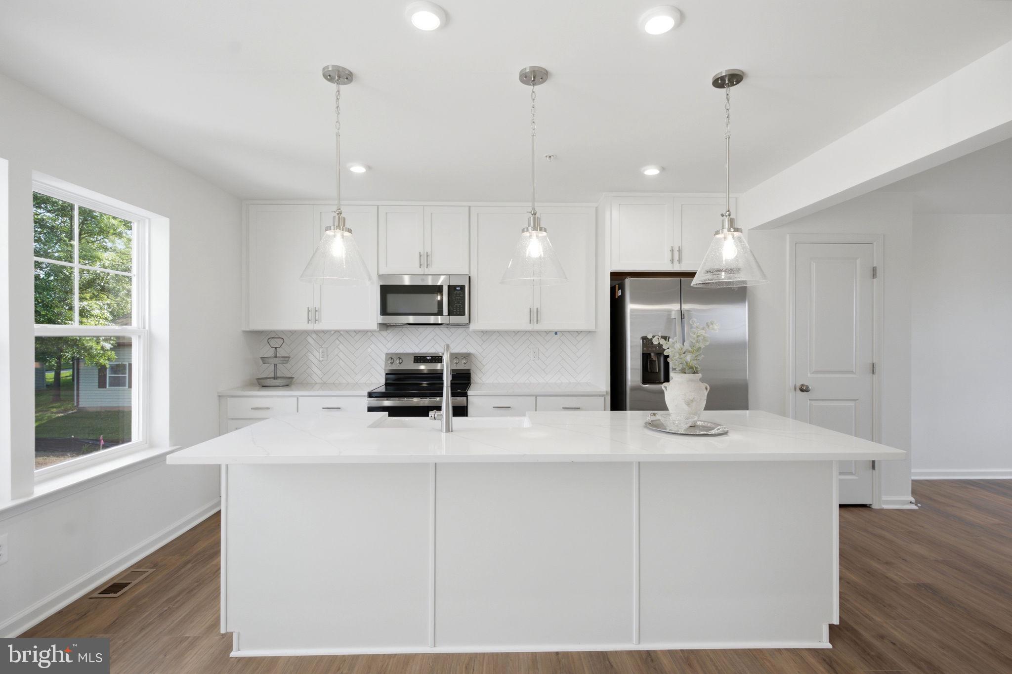 *OFFERING CLOSING ASSISTANCE FOR PRIMARY RESIDENCE WITH USE OF APPROVED LENDER AND TITLE.*
MOVE-IN READY! Welcome to Table Rock Terrace—where modern style meets effortless living just minutes from the charm and history of downtown Gettysburg. This stunning, upgraded York II end-unit townhome is filled with natural light, elevated finishes, and an inviting layout designed for today’s lifestyle.

From the moment you arrive, the end-unit setting makes an impression, with additional side windows and a striking triple window on the main level that floods the home with sunlight. Nestled in a picturesque, tree-lined neighborhood near Gettysburg Area High School, residents enjoy a peaceful setting complete with a community walking trail and low-maintenance living—including trash, snow removal, lawn care, and landscaping.

Step inside to a warm and welcoming foyer featuring durable LVP flooring and a flexible lower-level space perfect for a home office, guest suite, gym, or additional living area. A full bathroom and easy access to the attached one-car garage add both comfort and convenience.

Upstairs, the main level offers a bright, open-concept design ideal for both relaxing and entertaining. Warm-toned LVP flooring flows throughout, creating a cohesive and stylish feel, while abundant natural light pours in through the triple front window and additional side windows. The gourmet kitchen is truly the heart of the home, showcasing beautiful sand wood tone cabinetry with 42” uppers, a deep white apron-front sink, stainless steel appliances, and stylish pendant lighting. Matte black finishes add a modern edge, while the glossy white backsplash provides a clean, crisp contrast. The quartz countertops shine with the look of luxurious marble, featuring subtle gold and brown veining that perfectly complements the warm cabinetry. Flowing seamlessly into the dining and living areas, this space is made for gathering and everyday living. A convenient powder room completes the level.

Upstairs, retreat to the spacious primary suite featuring a walk-in closet and a private, spa-inspired bath with a double bowl vanity, a 4-foot tile shower with a custom bench seat, and a sleek frameless glass door. Soft carpeting extends throughout the upper level, adding warmth and comfort to each bedroom. Two additional bedrooms offer flexibility for guests or workspace and share a beautifully finished hall bath. A conveniently located laundry area adds everyday ease.

With its end-unit design, abundant windows, and thoughtfully selected finishes, this home offers the perfect blend of style, comfort, and functionality. Ideally located near shopping, dining, grocery stores, and major commuter routes, Table Rock Terrace delivers low-maintenance living without compromise. Schedule your appointment today and experience this exceptional home for yourself!