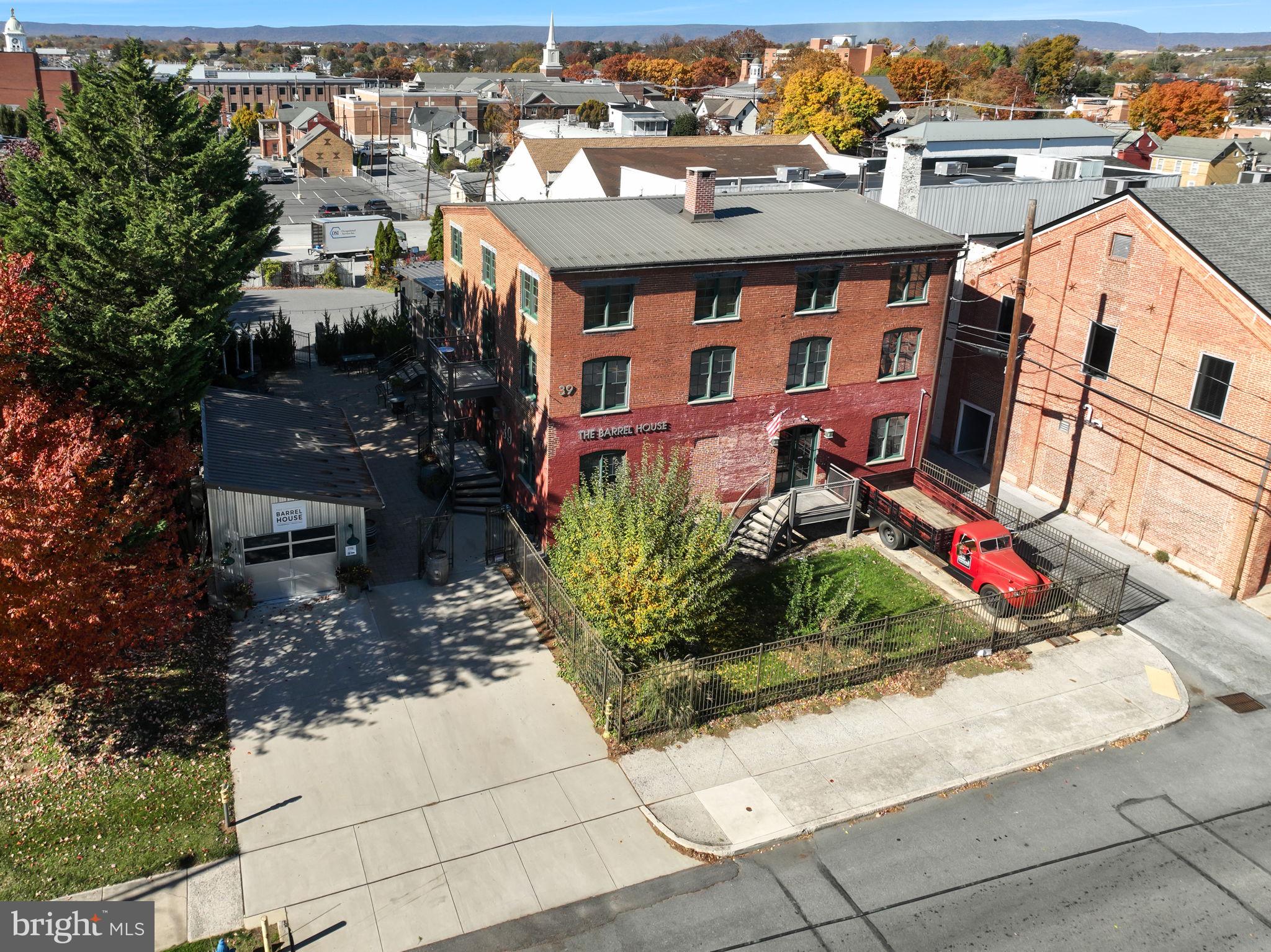 The Barrel House – Chambersburg’s Premier Multi-Use Destination! Step into The Barrel House, an exceptional opportunity to own one of Chambersburg’s most distinctive and versatile properties. This beautifully restored industrial-modern landmark currently serves as a bed & breakfast, wedding and event venue, restaurant, and brewery, but the possibilities are truly endless. Every inch of this building blends historic character with contemporary style, showcasing exposed beams, metalwork, and warm rustic details that tell the story of its industrial past. Endless Possibilities! Whether you envision continuing its legacy as a popular restaurant and event space, or reimagining it as a boutique hotel, creative co-working hub, or entertainment venue, The Barrel House provides the ideal foundation for a variety of ventures.
The Restaurant & Bar - At the heart of the property is a full-service commercial kitchen and a handcrafted bar that perfectly captures the building’s character. The spacious dining area invites guests to enjoy great food and drinks in an unforgettable atmosphere. Just beyond, the upper terrace accommodates up to 120 guests and is surrounded by dramatic industrial glass doors—open them wide for fresh summer air or close them to create a cozy, weather-protected setting with panoramic downtown views. Private Accommodations - The second floor offers a luxurious primary suite complete with a sitting room, office, sauna, kitchenette, laundry, and a spa-inspired ensuite bath, plus a balcony overlooking the terrace.
The third floor features three loft-style bedrooms and a full bath—perfect for overnight guests, staff quarters, or rental suites. A Rare Investment - Unique, stylish, and steeped in character, The Barrel House is more than just a property—it’s a destination. Opportunities like this don’t come along often.
Bring your vision to life at The Barrel House—where history, hospitality, and endless potential meet.