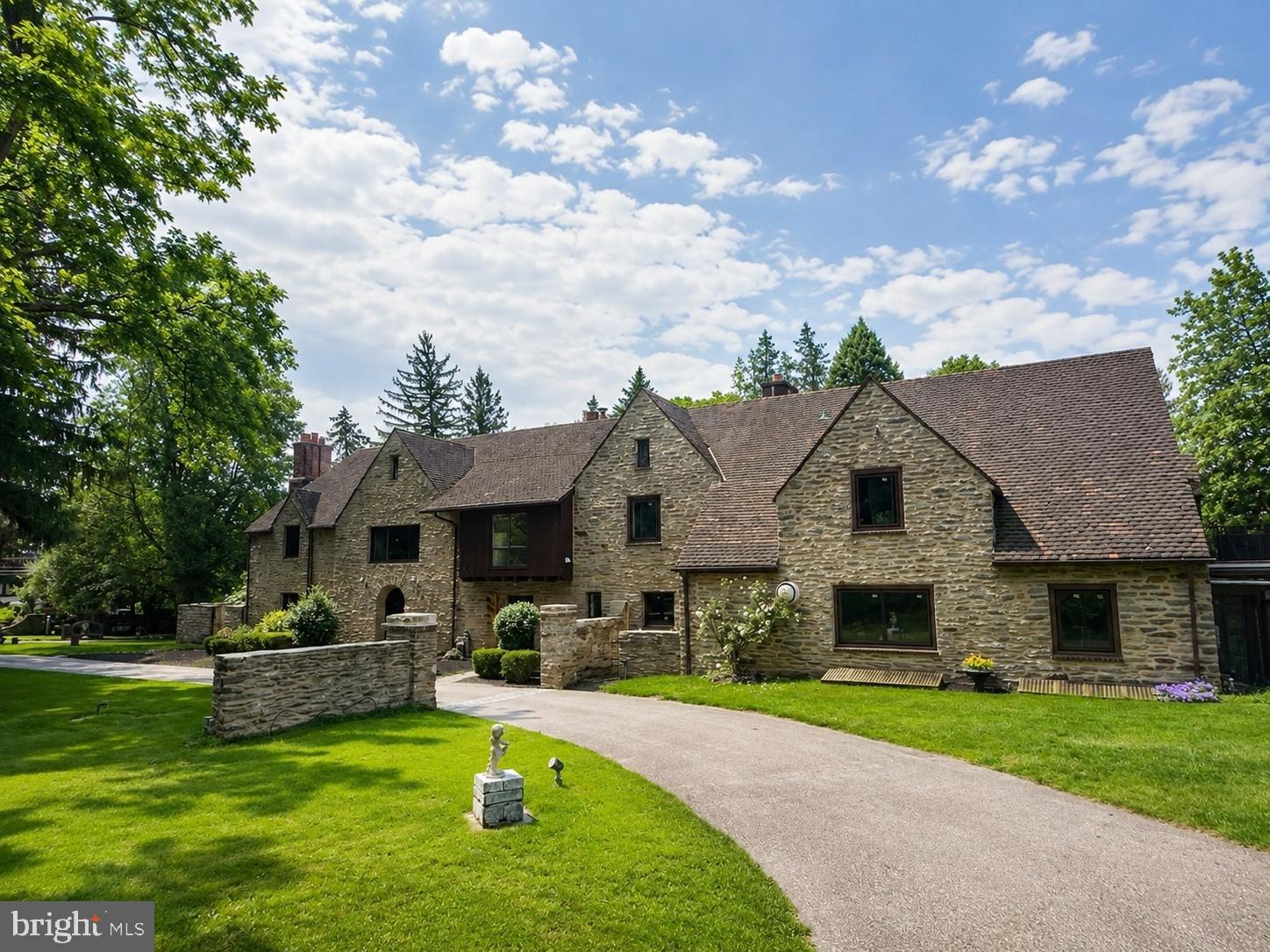 Set on 2.31 acres of private grounds, this 8,300+ sq ft stone estate offers a unique opportunity to own a 
compound-like property  Located in one of the Main Line’s most prestigious neighborhoods, this extra 
ordinary home features three self-contained living spaces, providing unparalleled flexibility. The main residence exudes warmth and elegance, with 8 bedrooms and 4 full baths, making it ideal for a growing household. Classic hardwood floors, multiple fireplaces, and exquisite custom woodwork create an 
inviting atmosphere throughout the home. The chef’s kitchen, with quartz countertops and a spacious prep area, serves as the heart of the home—perfect for both meals and entertaining. The formal dining room, adorned with rich wood paneling, provides an elegant setting for larger gatherings, while the cozy living room with its wood-burning fireplace is perfect for relaxation. The wood-paneled office offers a 
quiet retreat for work or study, and the renovated bathrooms, including two with luxurious steam showers, provide both comfort and convenience. A true highlight of this estate is the expansive gallery space—a versatile space with vaulted ceilings, exposed beams, and a striking stone fireplace. This self-contained area includes its own kitchen, modern bath, laundry, and private entrance, offering limitless possibilities. Whether used as a home theater, playroom, art studio, event venue, or even a dedicated guest suite, this exceptional space can easily be adapted to suit your needs. Above the detached garage, the carriage house apartment provides another private living space with its own kitchen, living room, bedroom, and bathroom—perfect for extended household, guests, or as a rental unit, The estate’s 2.31 acres create the perfect setting for outdoor enjoyment. Relax by the heated saltwater pool, host summer gatherings on the stone terrace, or unwind in the glass-enclosed sunroom overlooking the serene backyard. With dual private entrances from Remington and Morris Roads, the property offers complete privacy, while still providing easy access to surrounding amenities. Ample parking ensures your guests are always accommodated, making this estate ideal for reunions, holidays, or any large gathering. This estate is an extraordinary place to call home.