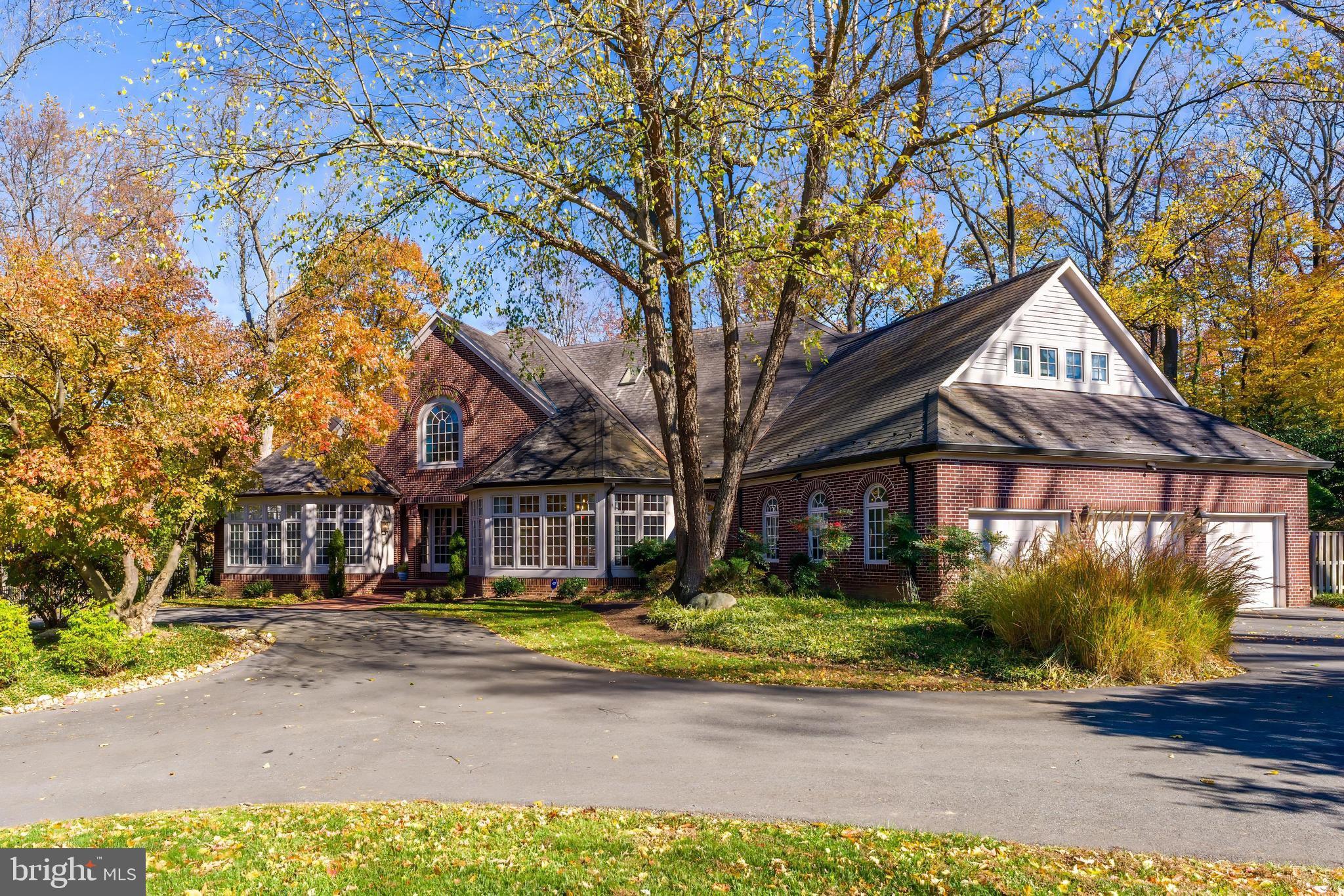 Sited on a beautifully landscaped private acre at the end of a quiet cul-de-sac, this special Colonial makes a memorable first impression. A circular driveway welcomes you to the property, setting the tone for the elevated living that unfolds inside. Thoughtfully designed and meticulously maintained, this home offers unexpected architectural details and refined spaces at every turn. Enter through the breathtaking two-story octagonal Foyer, flanked by the Living and Dining Rooms, each with three walls of floor-to-ceiling windows. The Living Room features a wood-burning fireplace, while the step-down Family Room offers another wood-burning fireplace, custom built-ins, and access to an Indoor Gathering Room with wet bar and French doors opening to a spacious paver Patio.
A Butler’s Pantry connects the Dining Room to the open Kitchen, featuring knotty pine cabinetry, granite countertops, a center island, and updated appliances. The bright Breakfast Room with its walls of windows and double doors to the Patio. A paneled Study, two Powder Rooms, Laundry, and Mudroom leading to a three-car Garage complete the main level.
Upstairs, the Primary Suite includes a private Foyer, Screened Porch, Sitting Room with deck, octagonal Bedroom, Dressing Room, walk-in closet, and a renovated Bath with skylight, dual vanities, whirlpool tub, tiled shower, and marble floors. Two additional Bedrooms (one of which could be divided into two separate rooms) and two full Baths complete this level.
The Lower Level offers a large Recreation Room with floor-to-ceiling stone fireplace, built-ins, and walk-in closet, plus a Craft/Office Room, Exercise Room, Wet Bar, Bedroom, Full Bath with steam shower and sauna, Utility Room, and storage.
The professionally landscaped grounds feature a heated 46’ x 18’ pool with automatic cover, separate whirlpool spa, fenced yard, lighting, and sprinkler system. Located in Bethesda’s desirable Bradley Hills neighborhood within the Walt Whitman School District, close to both public and private schools, country clubs, Downtown Bethesda amenities, and three major airports.
This is luxury, privacy, and location in one extraordinary home.