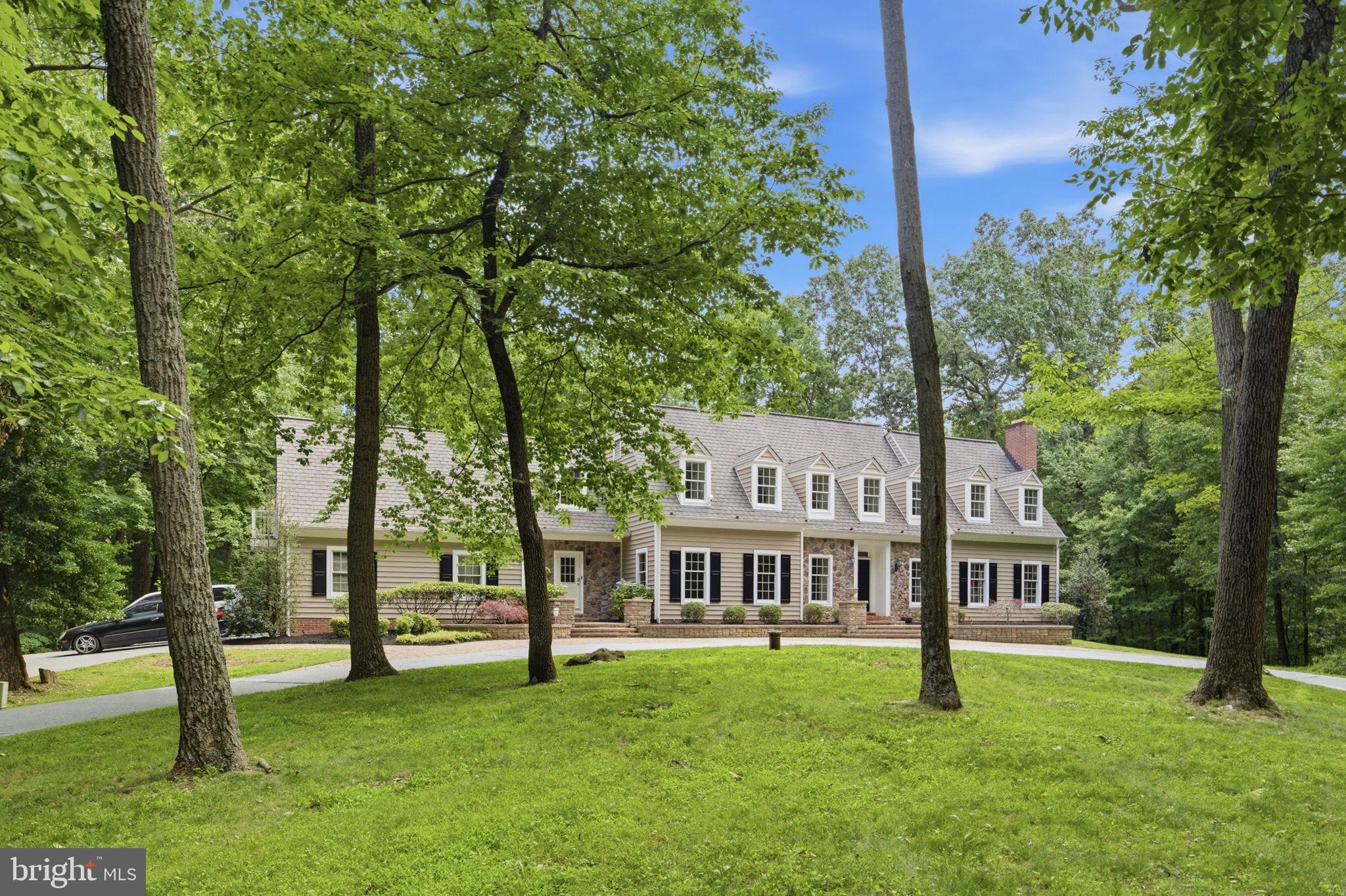 Custom-built estate home on 5+ private wooded acres with an elegant circular driveway and side-entry garage. Located next to preserved land, this property offers a peaceful setting with beautiful natural surroundings, open yard space, absolute privacy, and over 5,500 sq ft of living space.
Main level features a two-story entry foyer, hardwood floors throughout, formal living room with fireplace, large dining room, and spacious family room with vaulted beamed ceilings, stone fireplace, skylights, built-in sound system, and access to the screened porch and large deck overlooking the backyard and woods. Main-level office, two half baths, laundry room, and mudroom. Kitchen includes new granite countertops, newer stainless steel appliances, kitchen island, Italian tile flooring, and breakfast area overlooking the deck and backyard.
Upstairs offers 5 spacious bedrooms and 3 full bathrooms, including a large primary suite with fireplace, walk-in closet with recently upgraded closet system, and remodeled bath. Fifth bedroom features cathedral ceilings and private balcony access, perfect for a home office, studio, or entertaining space.
Fully finished walkout basement includes recreation room with stone fireplace, custom bar area, game room, additional bedroom, full bath, and large storage space. Walk out to the oversized stone patio and enjoy the private outdoor setting.
The home was fully remodeled in 2011, including new siding, and has seen many recent updates including roof (2020), well pump (2025), upgraded lighting, resurfaced driveway, restained deck, and neutral paint throughout. Additional features include 400-amp electrical service and Andersen windows throughout the home.
Conveniently located with easy access to commuter routes while offering a truly private wooded setting. A unique combination of space, privacy, and luxury living.