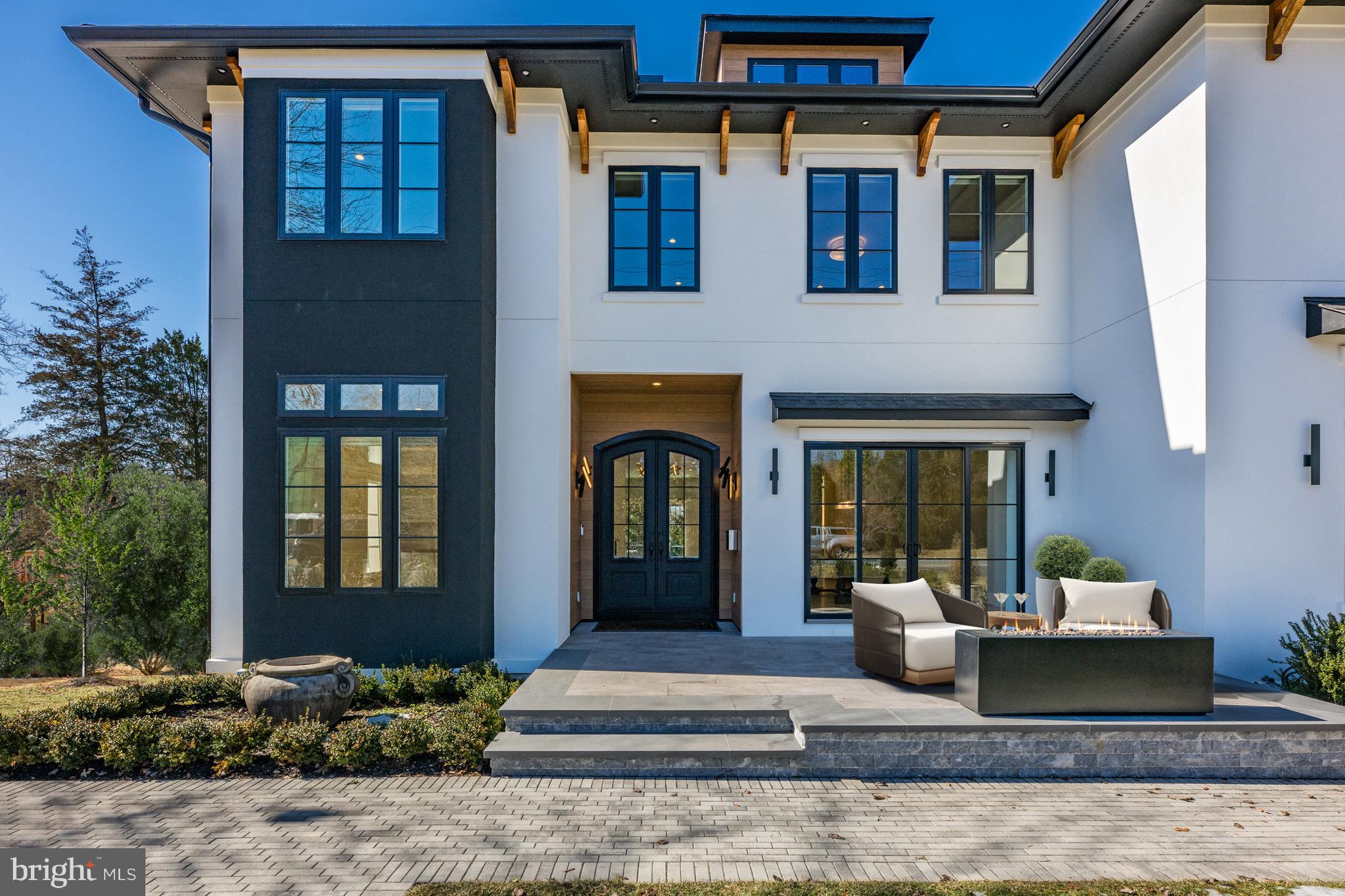 Experience contemporary elegance in this custom-built home by CRT Builders, with exquisite landscaping by Charles Owen of Fine Landscaping. Nestled in a prime location within walking distance of grocery stores, restaurants, top-rated schools, and parks, this residence offers both convenience and modern luxury. A charming front patio with a fireplace welcomes you, setting the stage for the inviting interiors. Inside, the foyer opens to a sophisticated library with custom built-ins and a formal dining room, where sliding glass doors seamlessly blend indoor and outdoor living. The beautifully designed butler’s pantry, complete with a beverage cooler, connects the dining area to a chef’s dream kitchen. Outfitted with top-of-the-line appliances, custom cabinetry, an integrated walnut dining table, and an oversized kitchen island, this space is both functional and stunning. Adjacent to the kitchen, a sunlit morning room with built-ins and the spacious family room that features a cozy fireplace, built-ins, and sliding glass doors leading to an expansive deck with a built-in outdoor kitchen-ideal for entertaining. Upstairs, the luxurious owner’s suite boasts a fireplace, two custom walk-in closets, and a spa-like bath with dual vanities, a freestanding tub, heated flooring, a heated towel rack, and a large marble double shower with a Steamist generator and touchscreen controls. Four additional ensuite bedrooms and a family sitting room with built-ins and a beverage chiller complete the upper level. The walk-out lower level is designed for entertainment and wellness, featuring a home theater, a fitness room with commercial-grade impact flooring, a wet bar with a temperature-controlled wine cellar and showcase window, plus a guest bedroom and full bath. Outside, the fully fenced backyard is a private retreat with a six-person hot tub, a gas fire pit, and a charming potting shed equipped with a half bath, potting table, and garden sink. Additional features include a ans elevator, whole-house generator, rooftop solar panels, and a three-car garage pre-wired for a 60-amp Tesla charger, with an extra-tall bay designed to accommodate an RV or a garage lift for two vehicles. Blending modern innovation with timeless elegance, this exceptional home offers an unparalleled living experience in the heart of McLean.