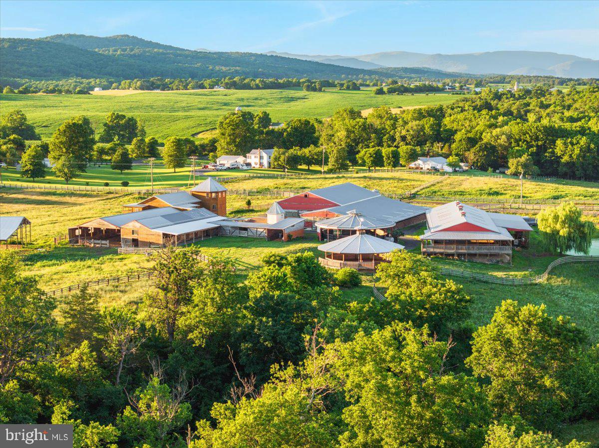 Welcome to an extraordinary opportunity to own over 80 acres of breathtaking countryside offering endless possibilities for equestrian, agricultural, business, and event use. This remarkable property combines multiple parcels to create a truly one-of-a-kind retreat featuring stunning mountain views, gorgeous rolling pastureland, and a beautiful creek flowing throughout the property. Fully fenced and thoughtfully designed, the land is ideal for horses, cattle, recreation, or creating the ultimate destination property. Equestrian enthusiasts will appreciate the impressive setup featuring multiple barns, a horse barn with 52 stalls, padded round pens, and an arena already in place. The property also includes an event space, operating office, living quarters, and an additional home ready to be finished into even more living space or guest accommodations. Several ponds add to the beauty and functionality of the land while creating peaceful scenic settings throughout the property. Whether you envision a premier equestrian facility, wedding or event venue, working farm, retreat center, or private estate, this incredible property offers the space, infrastructure, and natural beauty to bring your vision to life. Rarely does a property of this size and versatility become available with so much already established and ready for its next chapter.
