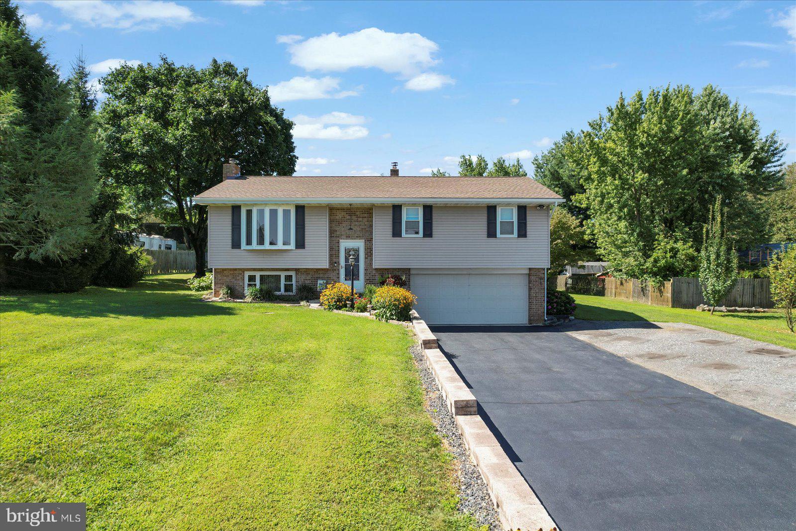 Discover the charm of this beautifully maintained raised ranch nestled on a 1.32-acre lot. This home offers the privacy of country living with the convenience of being close to town and the Maryland line. With a large kitchen, three bedrooms and two full baths, this home provides ample living space. The finished basement features additional space and a cozy wood stove that can be used for primary or secondary heat. Just a step outside the kitchen, this home features a screened in porch with a large attached outdoor deck, perfect for entertaining or finding a cozy spot close to nature. As a bonus, this home comes furnished with a working hot tub. The yard offers privacy with beautiful landscaping, mature trees, and bushes that provide an abundance of summer berries for picking. Parking is a breeze in the two car garage and over the recently sealed asphalt driveway. Additionally, this property offers a 24x32 two story detached garage equipped with running water, electric, and a new roof and siding (2019). Other home upgrades include new roof (2023), new windows (2017), new hot water heater, and a bathroom remodel.