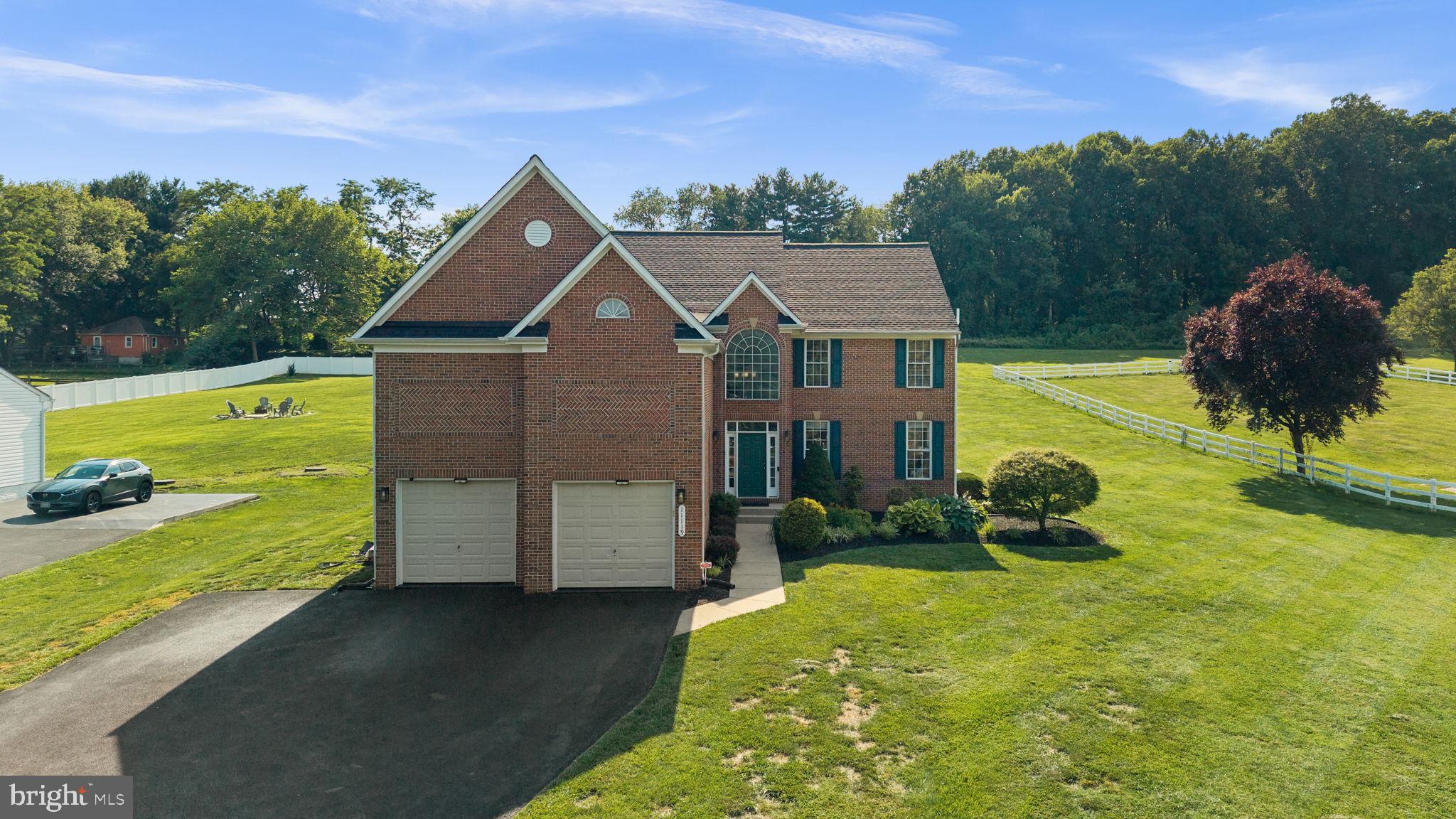 Beautifully updated Colonial residence situated on a spacious homesite in desirable Woodfords Grant II. Offering 5,951 finished square feet, this impressive home showcases numerous recent updates completed in 2026, including a recently replaced roof, fresh interior paint throughout, refinished hardwood floors, newly installed lower-level carpeting, a resealed driveway, and a refinished and sealed garage floor. // A long driveway with ample parking, lush landscaping, a stately brick façade, and glimpses of the surrounding pastoral landscape create exceptional curb appeal and welcome you inside. Bright, open living spaces and timeless finishes define the traditional floor plan, beginning in the dramatic two-story foyer with hardwood flooring. To the right, the formal living room is filled with natural light from oversized windows and flows seamlessly into the elegant dining room, accented by chair railing and a classic chandelier. // The beautifully renovated eat-in kitchen (2026) serves as the heart of the home, featuring quartz countertops, white cabinetry, stainless steel appliances, a center island with breakfast bar seating, a pantry, a built-in writing station, and hardwood flooring. The adjoining breakfast room provides patio access and opens directly to the inviting family room, where plush carpeting, a ceiling fan, and a wood-burning fireplace create a warm and welcoming gathering space. A private hallway leads to a versatile main-level bedroom or study, a full bathroom, and a mudroom with garage access, completing the main level. // Upstairs, the luxurious owner's suite is highlighted by soaring cathedral ceilings, a spacious walk-in closet, and a private ensuite bath featuring a corner soaking tub, dual-sink vanity, separate shower, and private water closet. Three additional bedrooms offer flexible accommodations, including one with its own private ensuite bath and walk-in closet, and two that share a dual-entry bathroom. One of these bedrooms also features dual closets and direct access to an unfinished attic space, offering outstanding potential for future expansion or abundant storage. A laundry room with a large walk-in linen closet completes the upper level. // The fully finished lower level expands the home's living space with a spacious recreation room, a full bathroom, a dedicated exercise room with walk-up backyard access, and a versatile bonus room behind French doors, ideal for a home office. // Outdoor living is equally impressive with a paver patio accented by a stone retaining wall and landscaping overlooking the expansive backyard. Backed by trees and equipped with an invisible electric fence, the private outdoor setting provides ample space for entertaining, recreation, or simply enjoying the peaceful surroundings.
