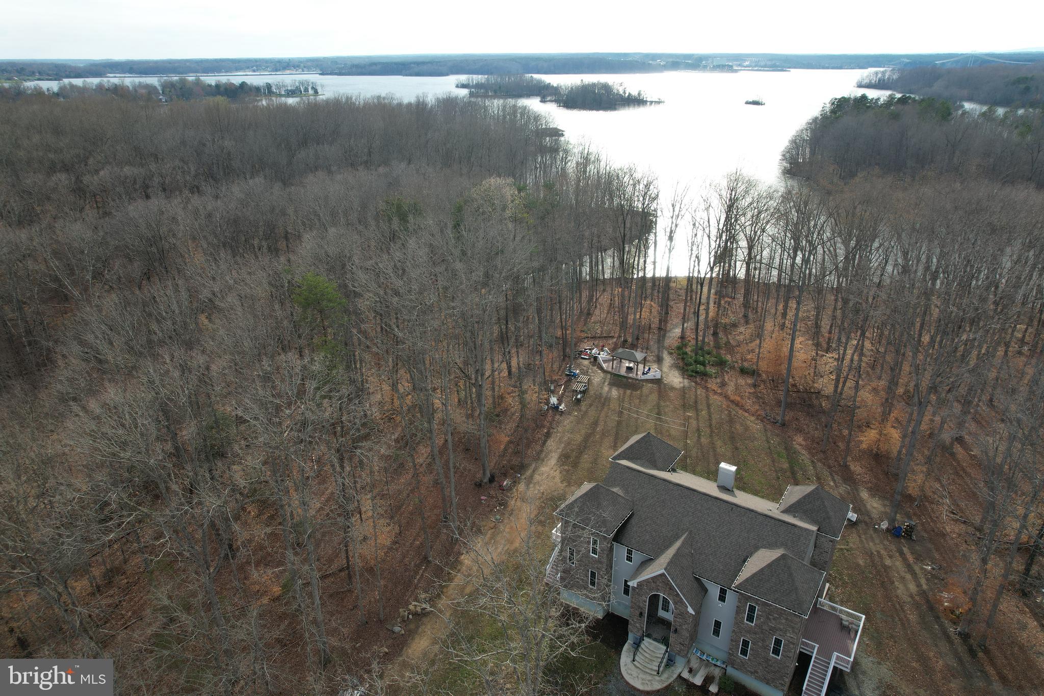Embrace the allure of living at the Lake View Castle Retreat with LAKE ACCESS, a splendidly renovated home with everything NEW offering a captivating blend of modern comforts and scenic beauty. This huge lake castle like home constructed with 2”X6” framing roughly 7, 000 sq ft, boasting SIX (6)+ bedrooms and five and half (5.5) baths are waiting for you. This lake view castle easily accommodates 16+ guests or two families/in-law suite, making it an ideal destination for families and friends seeking an immersive lake castle life experience. The luxurious Lakeview Master Suites, every corner of the house with open floor plan exudes comfort and style. Step into the heart of the home—the kitchen with NEW Stainless-Steel Appliances, a space that invites culinary delights. Stepping into the great room has a 24 ft ceiling with 6 professional massage chairs/couch with the huge TV for family entertainment provides a warm and inviting atmosphere, creating the perfect setting for relaxation and shared moments. From there, step outside to the outdoor play area, where the charm of the lake castle extends to nature-filled spaces, promising endless joy for both children and adults. THREE (3) NEW huge decks and a HUGE PATIO with an ENORMOUS VIEW of the LAKE is a PARADISE!  Lake access becomes an integral part of the Lake Castle Retreat experience. Launch boats, jet skis, or kayaks just minutes away from High Point or Anna Point ramps, unlocking a world of water adventures. Revel in the beauty of the MAGNIFICENT WATERVIEW, a one-of-a-kind spectacle that adds to the allure of this lakeside haven. Positioned conveniently, the Lake Castle Retreat is a mere 30 minutes from King Dominion Amusement Park and a short 1.5-hour drive from Washington DC or MGM Casino/National Harbor, Tyson Corner Mall, making it an accessible and attractive destination for leisure and shopping. As the day unfolds, savor the breathtaking views and sunsets on the enormous deck with loved ones. Whether swimming, fishing, or roasting marshmallows by the fire pits, the property provides an array of recreational activities. Venture into the wooded areas to explore wildlife, creating unforgettable memories in the heart of nature. Wait! step down to the newly finished basement/man cage with full kitchen, wet bar, pool table, professional poker table for late night entertainment. Are you prepared to embark on a memorable journey at Lake Castle Retreat?  Let every moment become an opportunity to build cherished memories.  Perfect for VACATION HOME OR SHORT TERM RENTAL!

1, Custom and newly renovated throughout all levels with open floor plans 10ft-24ft ceilings

2. new kitchen appliances for both kitchens

3. all new 5.5 bathrooms 

4. 2 master suites bedrooms plus 2  bedrooms  in upper levels and option of two (2) additional bedrooms in the basement

5, massage chairs in great room for entertainment

6, 3 new decks and a boat patio for outside entertainment

7. New 6" gutters are in the work of replacement

8. soil study was done for additional bedrooms as needed (can be expanded to 6 bedrooms) see soil study records attached.

9. Electric car charger installed 

10. Top of the line Jetski 2019 Seadoo GTX 300 with less than 50 hours and 2017 Yamaha Jetski with less than 90 hours on a newly installed assigned slip.  These are available for sale as a package deal as well. 

11. All furniture and entertainment equipment  inside the house are available for the full package deal as well. 

12. Built in 2017 with 4.17 Acres with back to water and trees