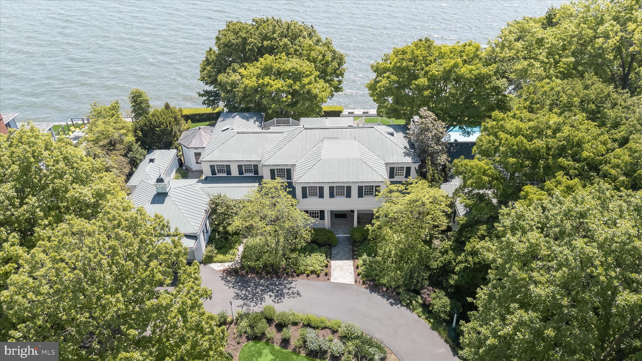 Sited along the storied Chesapeake Bay, with breathtaking views, proximity to the water, and exceptional landscaping, this spectacular Gibson Island listing offers a once in a generation opportunity to capture and enjoy the unique marvels of life along the Bay. The five-bedroom, five and a half bath estate, sitting on a rare double lot, offers generous living spaces and a timeless casual elegance perfectly suited to its idyllic location. The house also overlooks expansive stone terraces, lovely seasonal flowers and grounds, and a 63-foot heated lap pool with 180-degree panoramic views of the Bay.
Built in 1928 and beautifully renovated and expanded over time, the interior of this spectacular home unfolds with gracious rooms, inviting gathering places, classic architecture, a restful and spacious primary bedroom suite, superbly designed Bayside porches, hardwood floors, a main level guest bedroom with separate entrance, and a host of unique features and amenities befitting such a stunning property. The rooms offer carefully designed finishings that speak to both entertaining and comfortable family living. A property of this caliber and scale—combining a cherished residence, exceptional waterfront positioning, and a double lot—rarely comes to market on Gibson Island. With the Bay Bridge in the distance, it stands with the finest examples of Chesapeake Bay and Gibson Island waterfront property.

Information on Gibson Island:
Gibson Island is a private island within one hour of Washington, D.C. and Baltimore offering an absolutely extraordinary setting.  The Island comprises 1000 acres with seven miles of shoreline. Two thirds of the Island is undeveloped and is owned by the Gibson Island Corporation, the homeowners' association.  The remaining third is residential home sites. 
Gibson Island is located on the western shore of Maryland, so there is no need to cross the Bay Bridge. On the Island is a 43-acre spring fed freshwater lake in which one may enjoy non-motorized watercraft activities such as paddleboarding, canoeing, kayaking, fishing and swimming.  
The Island offers enormous privacy and security--there is an entry gatehouse staffed 24+Hours, and the Island is patrolled by the Gibson Island Police Force (GIPD).  The Gibson Island Corporation Service Department offers yard maintenance and landscaping and other services for homeowners.  There is a full-service yacht yard.   From the Island, it is just a 20-minute drive to BWI Airport and the neighboring Amtrak train station.  
The Island houses a private country club (membership by invitation) offering yachting, fine dining year-round, tennis, an award-winning Charles Blair Macdonald designed 9-hole golf course, swimming, croquet, skeet shooting, and more.  (C)