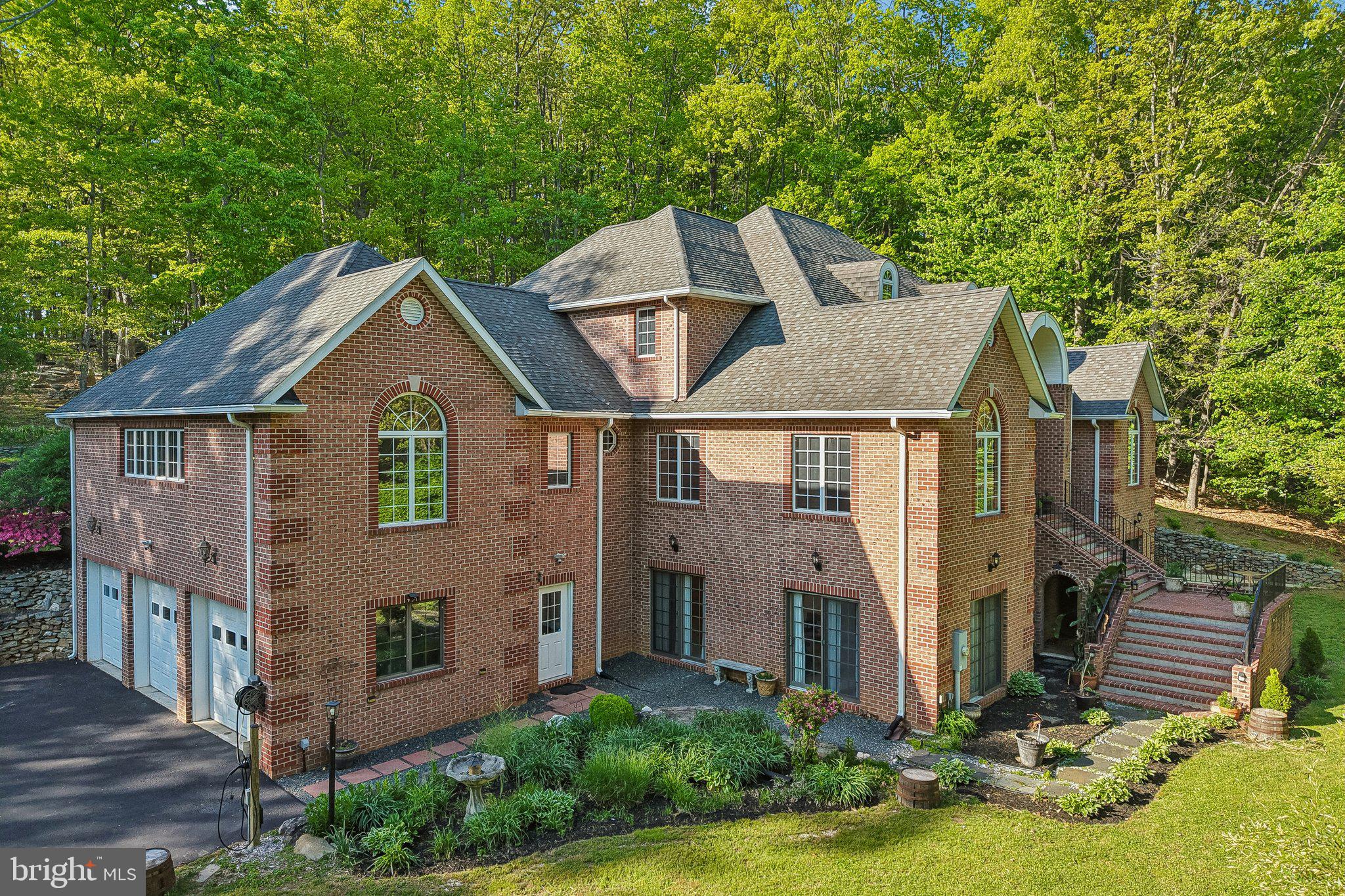 Experience refined country living in this custom-built, all-brick estate nestled on a pristine and private 5-acre wooded lot in Street, Maryland. This exceptional 6-bedroom, 4.5-bath residence blends timeless craftsmanship with modern luxury, offering an impressive combination of space, elegance, and tranquility.

Step inside to a grand two-story foyer with a sweeping dual staircase, setting the tone for the home’s sophisticated design. Soaring ceilings, an exquisite trim package, and rich hardwood flooring flow throughout an open, light-filled layout framed by oversized windows that capture the beauty of the surrounding landscape. The heart of the home is a dramatic two-story family room featuring a striking brick fireplace, dual patio sliders, and an elegant second-floor overlook, creating a truly breathtaking gathering space.

The gourmet chef’s kitchen is a showpiece, appointed with quartz countertops, a stunning waterfall island, and high-end stainless steel appliances—including a built-in ice maker, vegetable refrigerator, and a pot filler above the commercial-grade gas Wolf range. Just beyond, an expansive, light-filled dining room with a wet bar provides the perfect setting for both intimate dinners and large-scale entertaining.

Designed for flexibility and comfort, the home features dual primary suites on both the main and upper levels, ideal for multigenerational living or extended stays. A spacious main-level office offers versatility as a study or additional bedroom.

The fully finished lower level is an entertainer’s dream, complete with a refined wet bar, soda fountain station, dedicated exercise area, wine cellar, and a private guest suite with full bath—offering endless possibilities for recreation and relaxation.

Everyday living is elevated with a luxury laundry suite featuring dual washer and dryer sets, a steam closet for garment care, and a built-in dog bathing station. Additional thoughtful upgrades include central vacuum system readiness and motion-sensor illuminated mirrors in all bathrooms.

Outside, enjoy your own private oasis on five expansive acres, complemented by a spacious three-car garage and a freshly sealed driveway with long-lasting protection. Enhancing the property’s value, select equipment conveys—including a zero-turn mower (24HP, 54” fabricated deck, approximately 100 hours), Ohio Steel plow, and soda fountain system.

Located just minutes from shopping, dining, and commuter routes, this remarkable estate offers the perfect balance of privacy and convenience. A rare opportunity to own a truly exceptional home—where luxury, space, and lifestyle come together seamlessly. Schedule a tour today!