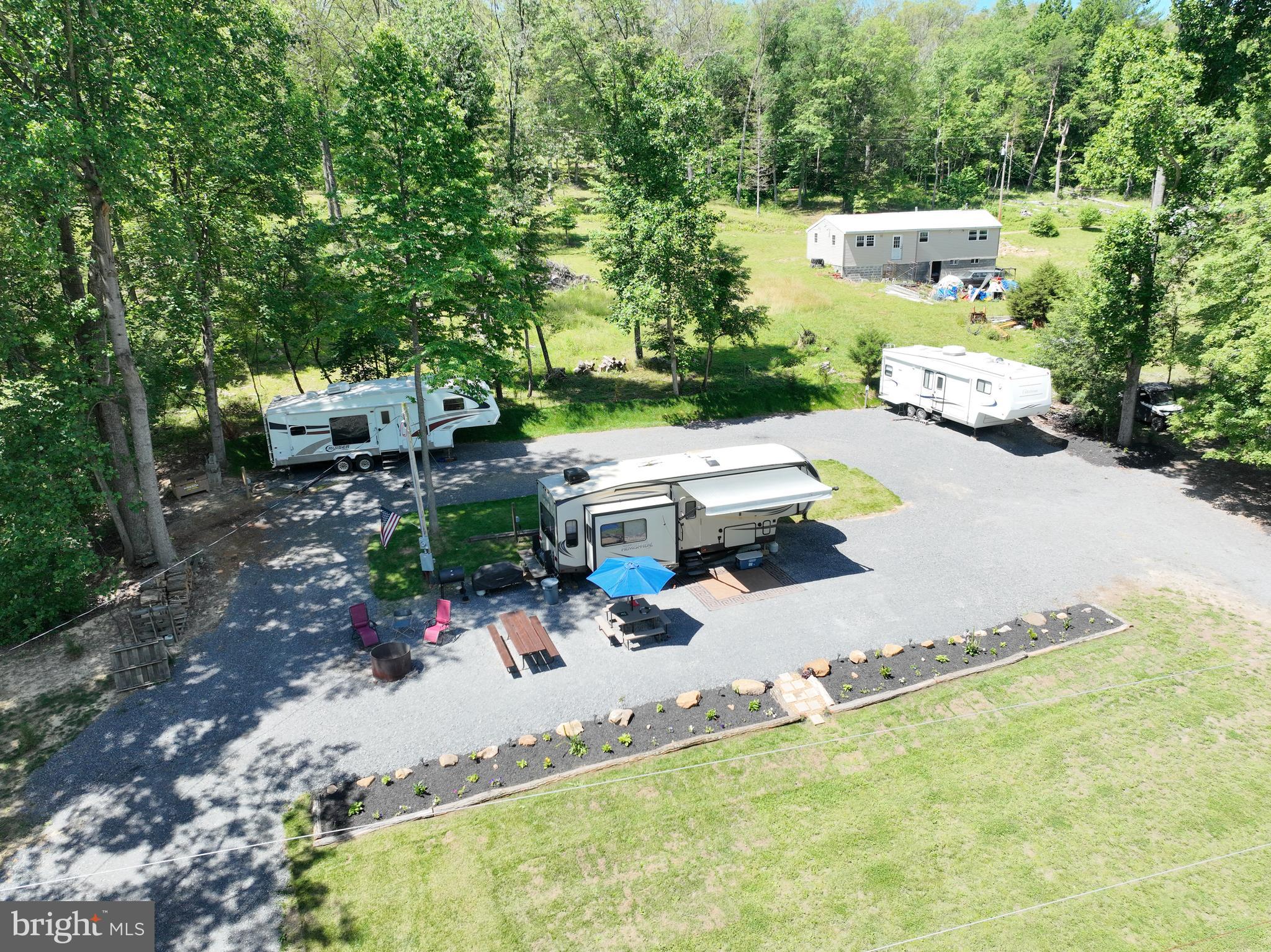 Escape to your own slice of mountain paradise in Great Cacapon, West Virginia, where the tranquil river beckons for endless days of relaxation and adventure. This property offers deeded river access, ensuring years of fun-filled activities floating, kayaking, and fishing.  Situated on two separate lots totaling 0.34 acres, this beautiful mountain getaway boasts all the amenities for a perfect retreat. The lot is fully improved, featuring full hook-ups for up to three recreational vehicles with 30/50 amp service, making it ideal for gatherings with family and friends and the perfect place to share the good times!   The 33 foot 2016 Forest River 5th wheel is included in the sale of this property!  The Hemisphere Lite has 3 slide outs and is in excellent condition.  The enhancements to this property are extensive, including a well, septic system, and electricity, providing the comforts of home in a serene setting. The land has been meticulously graded and graveled, offering easy access and ample space for outdoor enjoyment.  A 20-foot deeded right of way directly across from the property,  ensures convenient access to the river, which has been improved with steps and a beach area for effortless enjoyment of the water. According to the seller, the water gently progresses to approximately 13 feet in depth, inviting you to bring your floats and dive in!  Just the right size for the little kids and the big kids!  Escape the heat and the hustle and bustle of city life and embrace the laid-back mountain lifestyle along the beautiful Cacapon River. With this property located outside the flood zone, it's the perfect location to build the getaway cabin you've always dreamed of.   Hunters and outdoor enthusiasts will appreciate the close proximity to over 2,200 acres of Wildlife Management land easily accessible  for public hunting, hiking & biking and only 6 miles from the C&O Canal and Potomac River!
