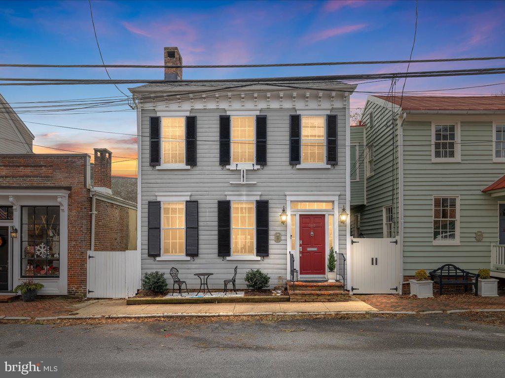 Nestled on one of the most picturesque and sought-after streets in Historic Annapolis, this stunning 3-bedroom, 2.5-bathroom home beautifully blends 19th-century charm with modern-day luxury. With no direct neighbors in front or behind, the home feels remarkably open and offers a sense of privacy that’s rare in this prime location. Step inside and be captivated by meticulously preserved historic craftsmanship, seamlessly combined with contemporary design.  An elegant living room with a converted gas fireplace offers a warm welcome into the home. The open-concept kitchen and dining area seamlessly connect to the inviting family room with a built-in bar, creating the perfect space for both everyday living and entertaining. Thoughtful renovations over the years have enhanced the home's style and comfort, including a new roof installed within the past five years.  Upstairs, all three bedrooms provide peaceful retreats, including a spacious primary suite with a private foyer, an en suite bath, and a deck overlooking the rear yard. From this vantage point, enjoy breathtaking views of the Maryland State Capitol dome—a striking sight by day and beautifully illuminated at night.  There is ample storage with a fully floored attic accessible from the primary bedroom, spanning its entire size.  Beyond the home’s exquisite interior, a large, privacy-fenced backyard with brick patio and lush landscaping provides the perfect outdoor oasis for entertaining or relaxing. This move-in-ready gem is just steps from Annapolis’ best attractions—walk to the waterfront, Ego Alley, the U.S. Naval Academy, Maryland Avenue, and Main Street’s vibrant shopping and dining scene. This is a truly rare opportunity to own an historic yet updated home in an unbeatable location.