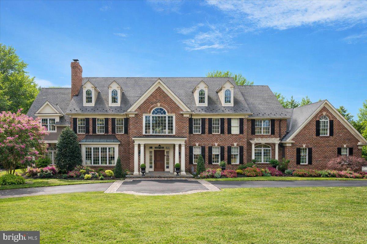 Sited on one of the Gwynedd Valley’s most coveted and private lanes, this magnificent manor home spans over 8,200 square feet and features six bedrooms, five bathrooms, and three powder rooms. The estate is perched on a lush, picturesque nearly 2.5-acre lot, highlighted by a double driveway entrance, swimming pool, and five car garage bays. This stately home offers the very finest in luxury living in Lower Gwynedd, showcasing unmatched design, old world brick craftsmanship, detailed custom millwork, and quality materials throughout. Having been completely remodeled down to the studs by the current owners. and meticulously maintained the property is in absolute move-in condition. 
Entering off of a tree lined private lane, the driveway leads to a bluestone entry terrace and handsome mahogany door, opening to a breathtaking two-story foyer. Inside the foyer you are flanked by stunning living and dining rooms—each adorned with finely crafted millwork. Adjacent to these spaces is a spacious, sunlit game room perfect for entertaining. The gourmet kitchen stands out with high-end custom cabinetry, a mahogany island countertop, six-burner gas cooktop, double wall ovens, wine fridge, wet bar, walk-in pantry, and a large breakfast room. French doors from the breakfast area open to a grand brick-laid covered terrace, ideal for large-scale entertaining. The family room is a showstopper, featuring handcrafted trusses and a beautifully cut fieldstone fireplace with custom mantle. Additional main floor amenities include an office, two powder rooms, and a modern mudroom with custom-in cubbies for everyday family living. Hardwood flooring runs throughout, complemented by numerous closets, arched doorways, classic built-ins, and both front and back staircases leading to the second level.
The second level is equally impressive. The primary bedroom suite is a true sanctuary, featuring his and her spacious closets outfitted with professional closet systems, a sitting room, and a spa bathroom with soaring ceilings and dual vanities. Down the beautifully arched long hallway are four additional spacious bedrooms, each with professional built-in closet systems, neutral bathrooms, and abundant natural light. A spacious laundry room is conveniently located on this floor, and a large in-law suite is situated just off the back staircase.
The lower level offers a range of amenities, including a movie theater, fitness studio, family gathering room, bathroom, wrapping paper/craft room, and abundant storage with additional stairwell access   from the primary oversized three car garage. The property also includes   a stately two-car detached carriage house with abundant storage.  On the second floor of the carriage house there is a full bath, closets and open space that can be used as an office, in law, or live in nanny space.
The current owners have made significant upgrades, including replacement of all electric systems, HVAC systems, primary bedroom closet remodel, installation of hardwood floors, new landscaping, construction of the carriage house, and more. The home is ideally situated in the award-winning Wissahickon School District and close to Philadelphia. This estate offers unmatched elegance, privacy, and convenience to outstanding schools, the PA Turnpike, vibrant downtown Ambler, three nearby train stations and effortless connections to Princeton and NYC—all within convenient range