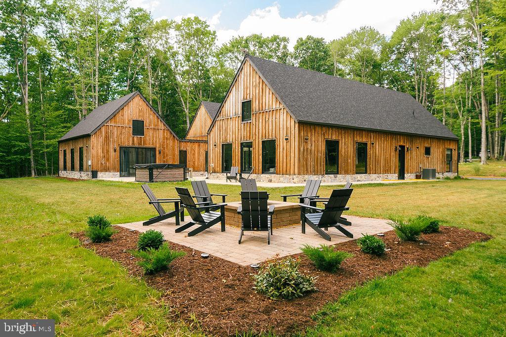 Welcome to Big Bass Lodge — a show-stopper retreat nestled in the heart of Maryland’s forested splendor near Deep Creek Lake. This expansive 4,300+ sq ft  estate sits on over 8 serene acres along the Youghiogheny River, bordering state ground and offering complete privacy, end-of-road access, and over 1,420 feet of river frontage that blends seamlessly into a wild-scenic state park setting. Designed for both grand gatherings and intimate escapes, the home features 4 bedrooms, 3.5 baths, and flexible layouts including a 900 sq ft loft/flex space with 3 twin beds. Unwind in the spacious hot tub for six, gather around the custom firepit, or launch games of bocce or cornhole under the treetops. Inside, a gourmet kitchen sets the stage for entertaining, while a large game room with wet bar, darts, poker table, and shuffleboard keeps energy high. The primary suite is a sanctuary unto itself — with walk-through closets, sweeping views, and even a ceiling design framed by the moon and stars. Thoughtful amenities abound: central A/C, high speed streaming, wide doorways/step-free access for accessibility, and sleeping setups that accommodate large groups (king, queen, bunks, twins, roll-aways). Minutes from Deep Creek Lake, Wisp Ski Resort, riverside trails, and golf courses, this is not just a home — it’s a legacy property, a high-end vacation asset, and a nature lover’s dream. Seize the opportunity to own a piece of Maryland’s most captivating landscape and lifestyle.