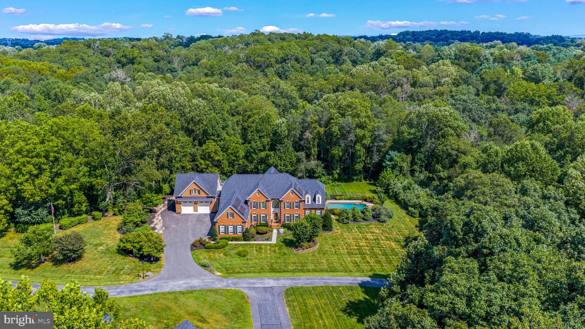 Introducing this stunning custom built brick colonial situated on 2.25 picturesque acres of landscaped grounds featuring 7 Bedrooms, 6 Full Baths, and 2 Half Baths over 9,500 sq ft of luxury living with all of the bells and whistles imaginable! Elegance and livability welcome you to this beautifully maintained property with a grand two-story foyer featuring hardwood flooring throughout the main level, custom columns, vaulted ceilings, crown molding, a grand split staircase, and ample windows providing a ton of natural light. The dream gourmet eat-in kitchen features top of the line stainless steel appliances, 42" cabinetry, granite countertops, tile backsplash, a large center island with plentiful storage, breakfast bar, walk-in pantry, custom under cabinet lighting, built-in dry bar, and ceramic tile flooring. With direct access to the screened-in trex deck, the kitchen also overlooks the expansive two-story family room with a coffered ceiling, palladium windows, custom built-ins, and a cozy fireplace. The separate formal living room and dining room offer a perfect place to entertain family and friends. Work from home in the private main level study with built-ins, peaceful backyard views, and an attached full bathroom. Relax in the one of a kind conservatory room with sun-drenched floor-to-ceiling windows with panoramic views and direct access to a 2nd trex deck overlooking the stunning private backyard. More bonuses include an attached 3 car garage, central vac, main level laundry room, owned solar panels, and a house generator. On the Upper level, the luxurious owners suite offers a sitting room, tray ceiling, massive walk-in closet, spa-like bath with separate vanities, glass enclosed shower, platform soaking tub, and linen closet. As you make your way through the upper level, Bedrooms 2 and 3 feature their own private attached full baths, and walk in closets. Bedrooms 4 and 5 share a jack and jill styled bathroom and also have their own walk-in closets. Adding to the amazing living spaces and entertainment areas, the finished lower level offers a perfect place to entertain, featuring 2 exercise areas, a bedroom with full sized windows and closet, full bathroom, custom wet bar with lighting, dishwasher, ice maker, refrigerator, cabinetry with custom lighting, a large family/club room, game room, full sized windows for lots of natural light, and a large storage/utility area. This could also be the perfect in-law suite; the options are unlimited! Step right outside to enjoy this resort-like backyard with a beautiful stone patio accessible from the walkout lower level, leading to a beautiful heated in ground pool – perfect for outdoor entertaining and relaxation. Exterior features include multiple entertaining areas stretching the full length of the home, large composite screened in deck off the main level with stairs to the backyard, expanded driveway/parking area, beautiful mature landscaping, large stone retaining wall, 2nd composite deck, storage, fenced in stone patio with fire pit and grill area. All of this surrounded by an open backyard play space with a protected forest area at the rear of the lot. Added in 2024, the 1,900 sq ft conditioned detached garage is a car enthusiasts dream! This space provides room for 4+ cars, a built in power washing station, powder room, upstairs office/gym/bedroom and bath. Fantastic commuter location just minutes to I-795, I-695, I-70, MD-32, MD-97, MD-91, MD-26. Enjoy a vast variety of shopping, dining, and entertainment in the towns of Westminster, Eldersburg, and Finksburg. Outdoor recreation awaits you at Sandymount Park, and Piney Branch Golf Club. This is an deal location set on a quiet, private lot ideally situated close to Liberty Lake and The Reservoir. This home is ready to enjoy & impress! (Roof replaced 2024)