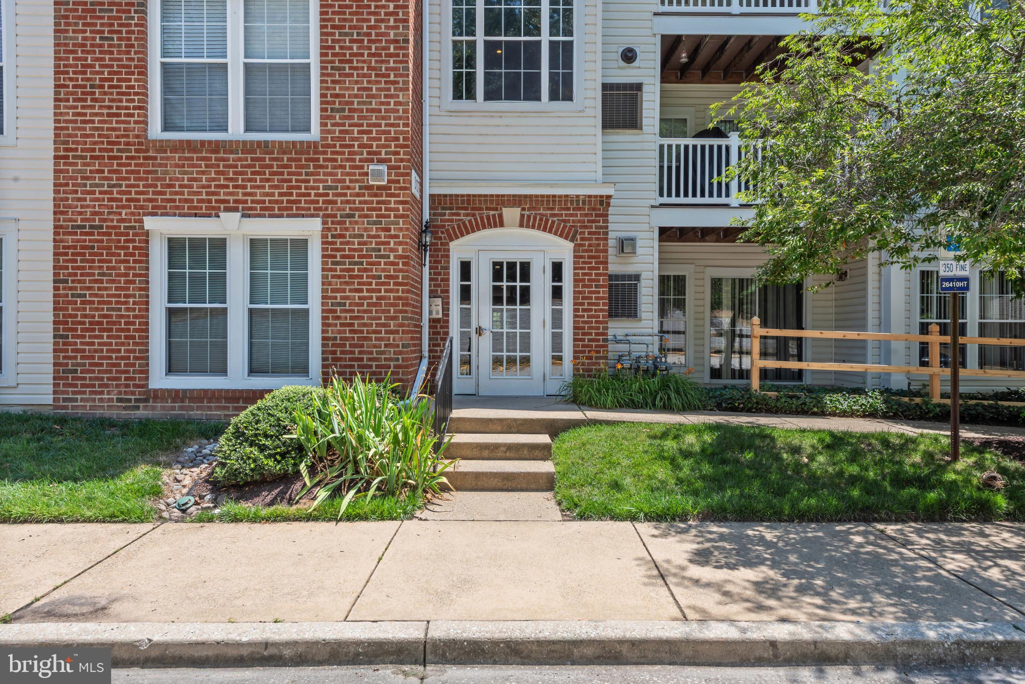 Beautifully maintained contemporary-style first-floor condominium residence offering 3 bedrooms, 2 full bathrooms, and 1,299 finished square feet in the desirable Oxbow Apartments at Russett. Conveniently located on the first floor while still elevated above ground level, this inviting home offers the ease of single-level living paired with added privacy. Step inside the freshly painted interior, where rich dark flooring and recently updated windows create a warm, inviting atmosphere throughout. Just off the foyer, a spacious laundry room with a full-size in-unit washer and dryer adds everyday convenience. Continue into the bright, open-concept living and dining area, where a cozy fireplace creates a warm focal point. The adjacent dining room is enhanced by a modern chandelier, built-in shelving, and a smooth transition leading to a covered balcony, creating a seamless indoor-outdoor living experience. The well-appointed eat-in kitchen features stainless steel appliances, white cabinetry, abundant countertop space, and a pantry. A sunny breakfast area framed by bay windows provides the perfect spot to enjoy casual meals while filling the space with natural light. The spacious owner's suite serves as a comfortable retreat with dual closets and a private ensuite bath featuring an extended vanity. Two additional bedrooms and a second full bathroom provide flexible space for family, guests, or a home office. Several closets throughout the home have been outfitted with custom California Closets® organization systems, adding both style and functionality. Residents of Russett enjoy an impressive collection of community amenities, including a clubhouse, outdoor pool, tennis and basketball courts, scenic trails, and tot lots and playgrounds, offering exceptional recreation and convenience for all ages.