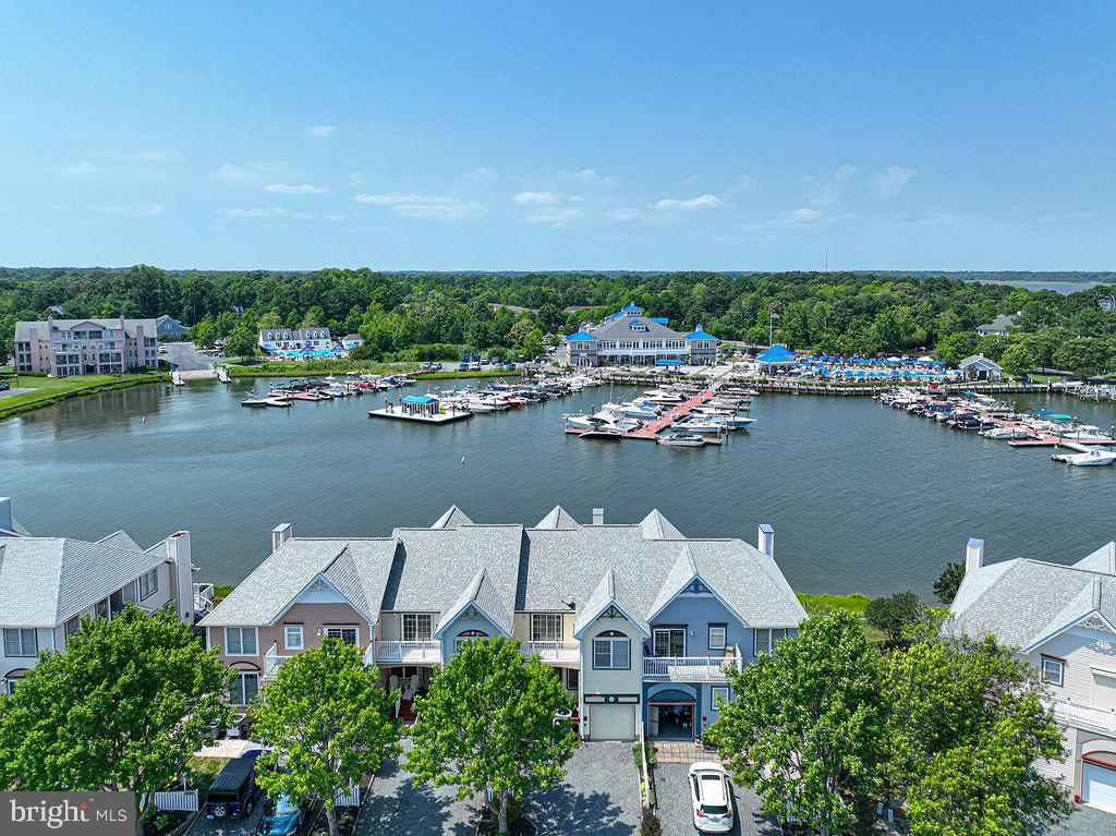 You will love the magnificent views from this charming coastal style 3 Bedroom, 2.5 Bath townhome within walking distance to the Yacht Club Dining and Pool Bar,  Pines Point Marina, or Mumfords Landing pool.  Enjoy panoramic views of the extra wide protected Lagoon surrounding the Yacht Club and Marina areas. The Ceramic Tiled Kitchen includes a Breakfast Area, Pantry, and leads to a semi-formal Dining Room, Living Room with gas fireplace, and sliding glass doors to the large rear deck!  Upstairs you will find 2 spacious guest bedrooms, Laundry Room, 2 private balconies, including one in the 16x15 Primary  Suite with a 12x7 walk-in closet.  Relax in your 16x8 Primary Bath with soaking tub, separate shower and double vanity.  The Marina Village HOA takes care of the yard and landscaping, and also paints exterior trim every 3 years! Extra bonuses include a single car garage, front porch, decorative picket fencing, and a screened porch!  Pines Point Marina Boat Slip B-38 is also available for purchase.  A brand new boat lift with remote and catwalk is being installed in July.  Accommodates a 24' Boat.