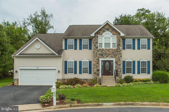 Welcome to this light-filled and beautifully maintained Sequoia model in the highly desirable Locust Hill community! Offering three fully finished levels of living space, this spacious home features 4 bedrooms, 3.5 baths, and a layout designed for both everyday comfort and entertaining.

The main level showcases gleaming hardwood floors, a gourmet kitchen with Corian countertops, center island, double wall ovens, workstation, and abundant cabinetry. Enjoy both formal and casual living with a separate dining room, spacious family room anchored by a stunning stone gas fireplace, convenient main-level laundry, and a private office perfect for working from home. Custom built-in bookshelves add charm and functionality to the front room.

Upstairs, the owner's suite serves as a private retreat featuring an upgraded walk-in closet, luxurious soaking tub, and separate shower.

The fully finished lower level offers exceptional versatility with a recreation area, additional flex room ideal for a gym, hobby room, playroom, or guest space, and wiring already in place for a surround sound system and projector—perfect for movie nights or game-day entertaining.

This home has been thoughtfully updated for comfort and efficiency, including updated heat pump and air conditioning systems, a heat pump with gas backup, water purification system, and a new water softener. The garage has been enhanced with custom storage cabinets to help keep everything organized.

Step outside to enjoy the peaceful wooded backdrop. Situated at the end of a quiet cul-de-sac and backing to mature trees, this property offers privacy and tranquility. Permanent exterior lighting adds year-round curb appeal and can be customized for holidays, special occasions, or everyday ambiance with the touch of a button.

Conveniently located for commuters, you'll enjoy easy access to major routes serving Northern Virginia, Maryland, and the Washington, DC metropolitan area while still enjoying the charm and lifestyle that make Locust Hill such a sought-after community.