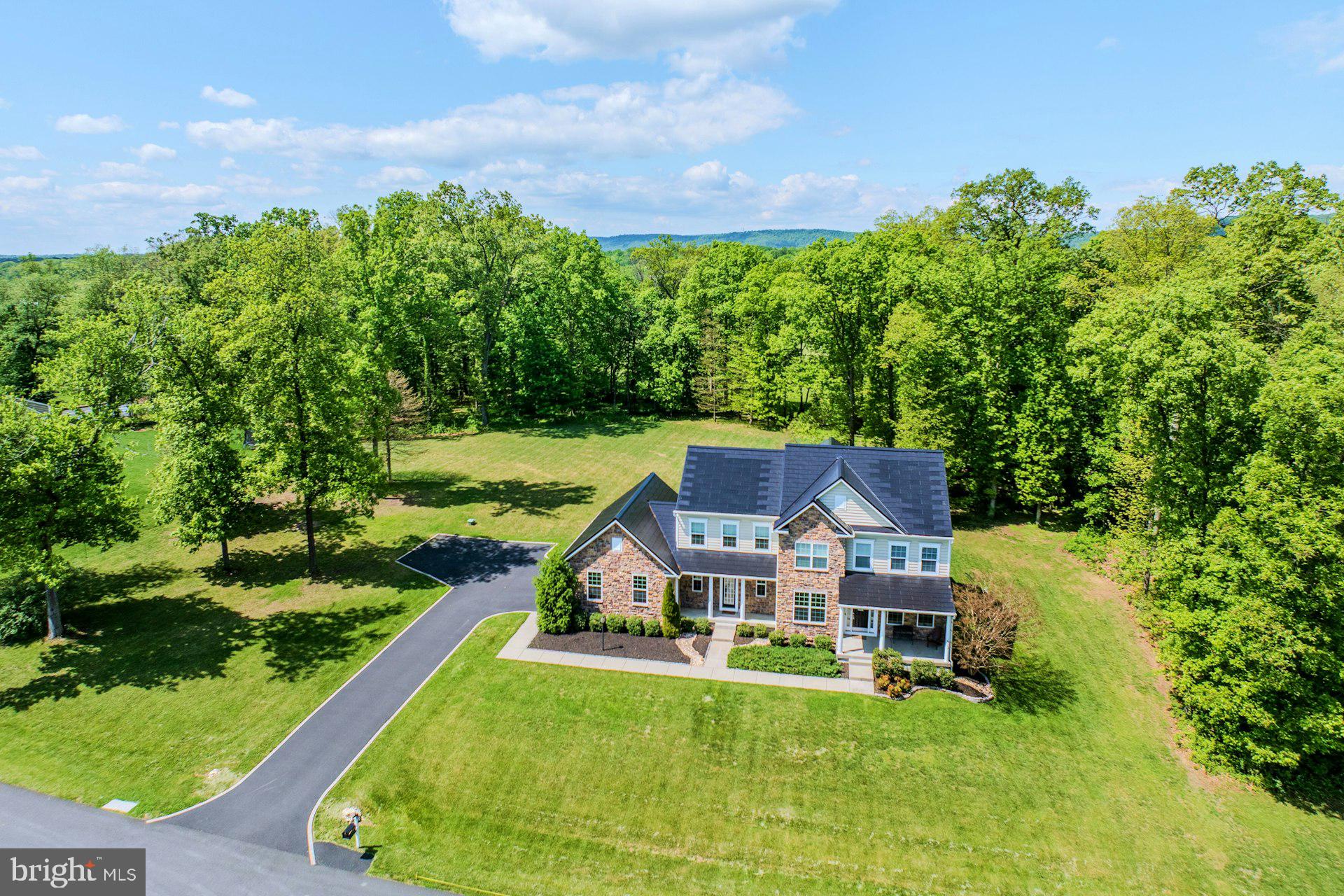 ---New Price---Welcome home to this stunning colonial peacefully situated on a 1.71 acre lot with over 5,300 square feet of living space & a Tesla solar roof system that was installed in 2025. The covered front porch greets you as you enter into the front foyer. Spacious living room, formal dining room & privately tucked place library on the main level ideal for working from home. Grand two story family room with stone surround gas fireplace & tons of light. Expansive gourmet kitchen with center island, stainless steel appliances, upgraded backsplash & morning room extension with access to rear yard for future outdoor space. Main level mudroom with additional exit to the outside & half bath too. Large primary suite with coffered ceiling, walk-in closet & luxurious bath with soaking tub & separate shower. The second bedroom features private bath. Third & fourth bedrooms share a spacious third bath. Walk-up lower level with recreation room with new carpet in 2025, 5th bedroom/den, fourth full bath, den/craft room & storage room. Oversized three car garage with car charger & expanded driveway allowing for additional parking.  This home is peacefully located on a paved cul-de-sac street with a large rear yard providing ample open space as well as trees providing privacy.