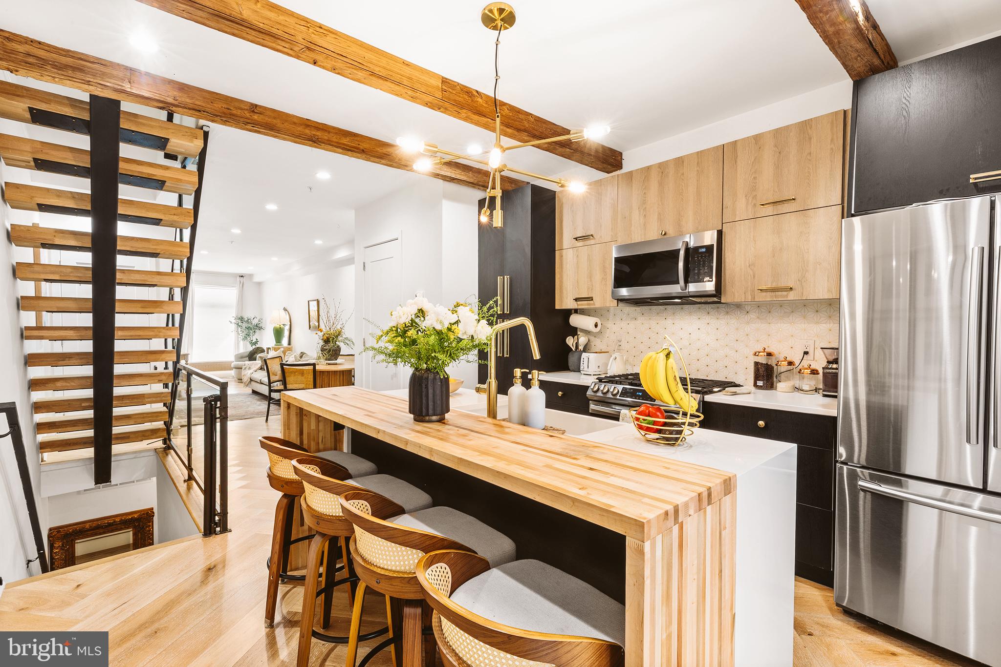 Built in 2022, this stunning home offers three bedrooms, three and a half bathrooms, and a flexible floor plan across three beautifully finished levels. A condo that lives like a house, with the design details to match. The main level features white oak herringbone floors, a custom media wall, and a built in bookcase. The chef's kitchen impresses with exposed wood beams, quartz waterfall countertops, dual tone cabinetry with brushed gold hardware, Carrara marble backsplash, farmhouse sink, Samsung appliances, and an island with seating for four. The primary suite is spacious and well appointed, with a shiplap ceiling, generous storage, and a strong ensuite bath featuring porcelain herringbone tile and an oversized walk in shower. Two lower level bedrooms with 10 foot ceilings and private baths offer serious flexibility for guests, a home office, or additional living space. Out back, a private patio with imported tile and a privacy fence rounds things out nicely. Steps from Francisville Playground, Eastern State Penitentiary, and the boutiques and restaurants lining Fairmount Avenue, with Whole Foods, the Barnes Foundation, and the Philadelphia Museum of Art all within easy reach with Center City just a 15-minute walk away. Shows beautifully.