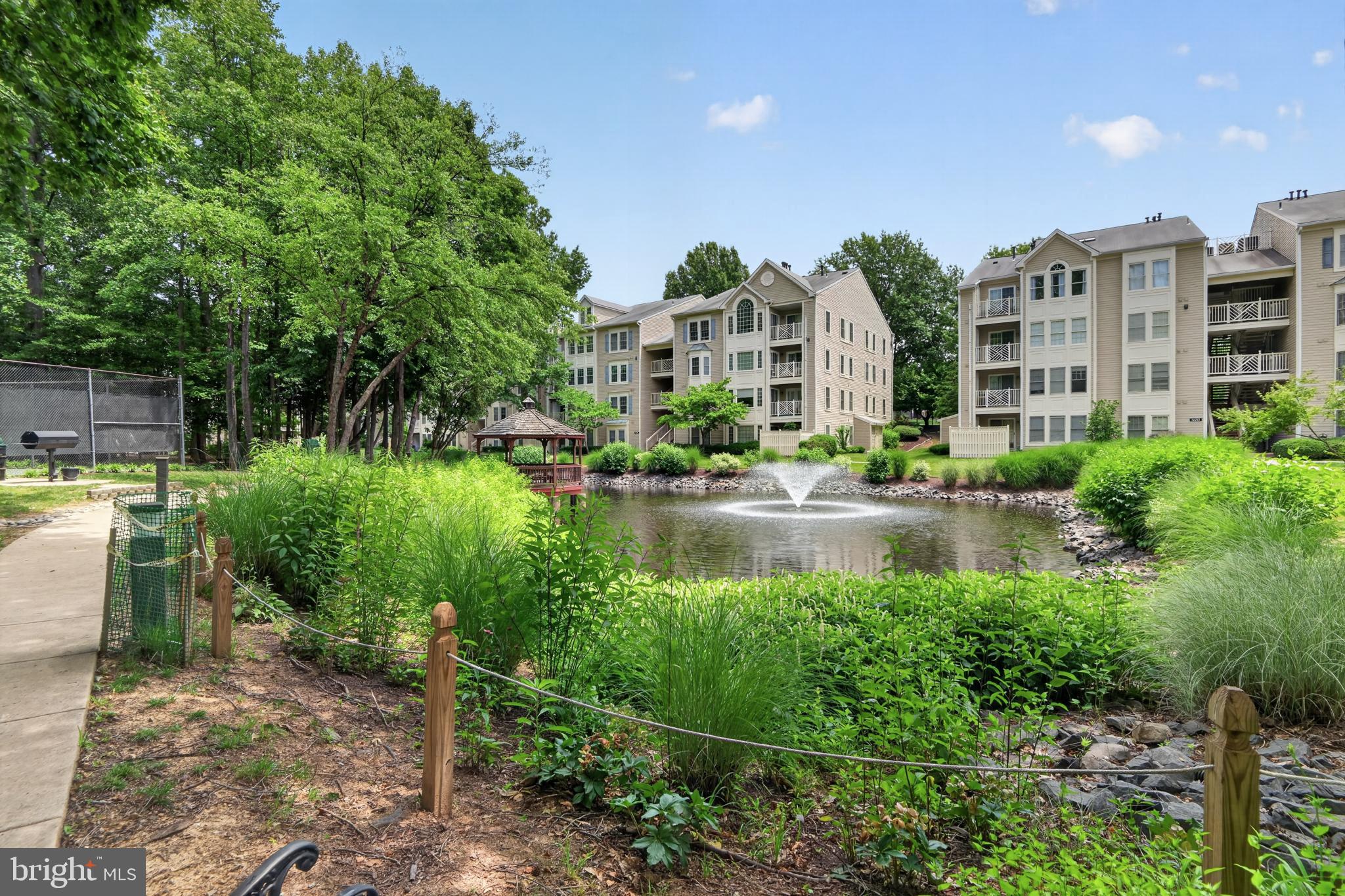 Welcome home to this stunning, sun-drenched two-level condo offering the perfect blend of modern comfort and effortless elegance. From the moment you step into the welcoming tile foyer, you are greeted by an expansive open-concept layout defined by soaring vaulted ceilings and an abundance of natural light. The heart of the home is the inviting living room, featuring built-in shelving and a cozy gas fireplace with a sophisticated marble hearth and surround—the perfect backdrop for crisp autumn evenings. Transition seamlessly to the adjoining dining room, illuminated by an updated contemporary chandelier, or step through sliding glass doors to enjoy your private balcony, complete with a convenient extra storage closet.

Culinary enthusiasts will appreciate the well-appointed kitchen, fully equipped with premium gas cooking, stainless steel and black appliances, crisp track lighting, and durable tile flooring. Retreat to the main-level primary suite, a peaceful sanctuary boasting its own vaulted ceiling, a direct sliding door to the balcony, a spacious walk-in closet with custom Elfa shelving, and an en-suite bath featuring updated marble tile and a luxurious jetted tub. A generously sized second bedroom also enjoys vaulted ceilings, a large walk-in closet, and convenient dual-entry access to a full bathroom.

Upstairs, the versatile second-level loft expands your living options, making it an ideal space for a home office, media room, or guest retreat. This upper level features a third full bathroom with marble tile flooring, a dedicated laundry room with a full-sized washer and dryer, and a deep closet providing valuable attic storage. Recent practical updates, including a new hot water heater (2023), carpet (2026) and a built-in fire sprinkler system, offer ultimate peace of mind.

Situated in a beautifully landscaped community, residents enjoy access to excellent amenities including a tennis court, a scenic pond with a gazebo, and a charming little library. Parking is a breeze with one reserved space and abundant unassigned parking for guests. Location is everything, and this home places you minutes from major commuter routes like I-66, Route 50, and the Fairfax County Parkway. Indulge in the area’s finest shopping, dining, and grocery options with Fairfax Corner, Fair Oaks Mall, Fair Lakes, Wegmans, and Whole Foods all just moments from your front door. This is Fairfax living at its finest!