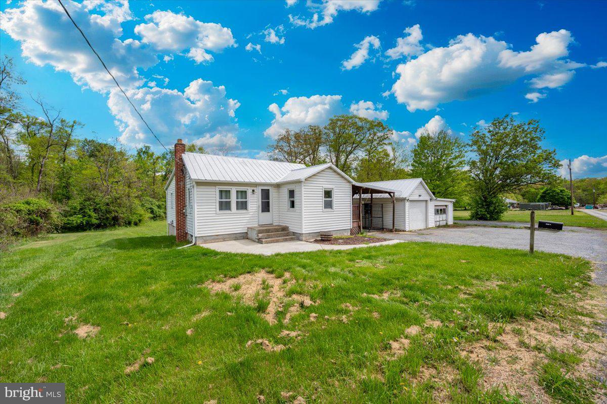 Country living with no HOA. Charming 2 bedroom, 1 bath cottage on just under an acre waiting for your personal touches. Eat-in kitchen with pantry and table space. This home features hardwood floors in the living room and dining room with fully carpeted bedrooms. The kitchen has a newer stove and updated countertop. Additional updates include: heat pump & a/c, water heater, water treatment system with UV light , in-line water filter, new well pump, replacement windows and freshly painted metal roof. No need to leave home to do your laundry; a washer & dryer are located in the basement. A covered patio keeps you out of the elements as you go to the 2 car garage. Enjoy the benefits of a level backyard for ease of outdoor living.  Being sold as-is, inspections are strictly for informational purposes only.