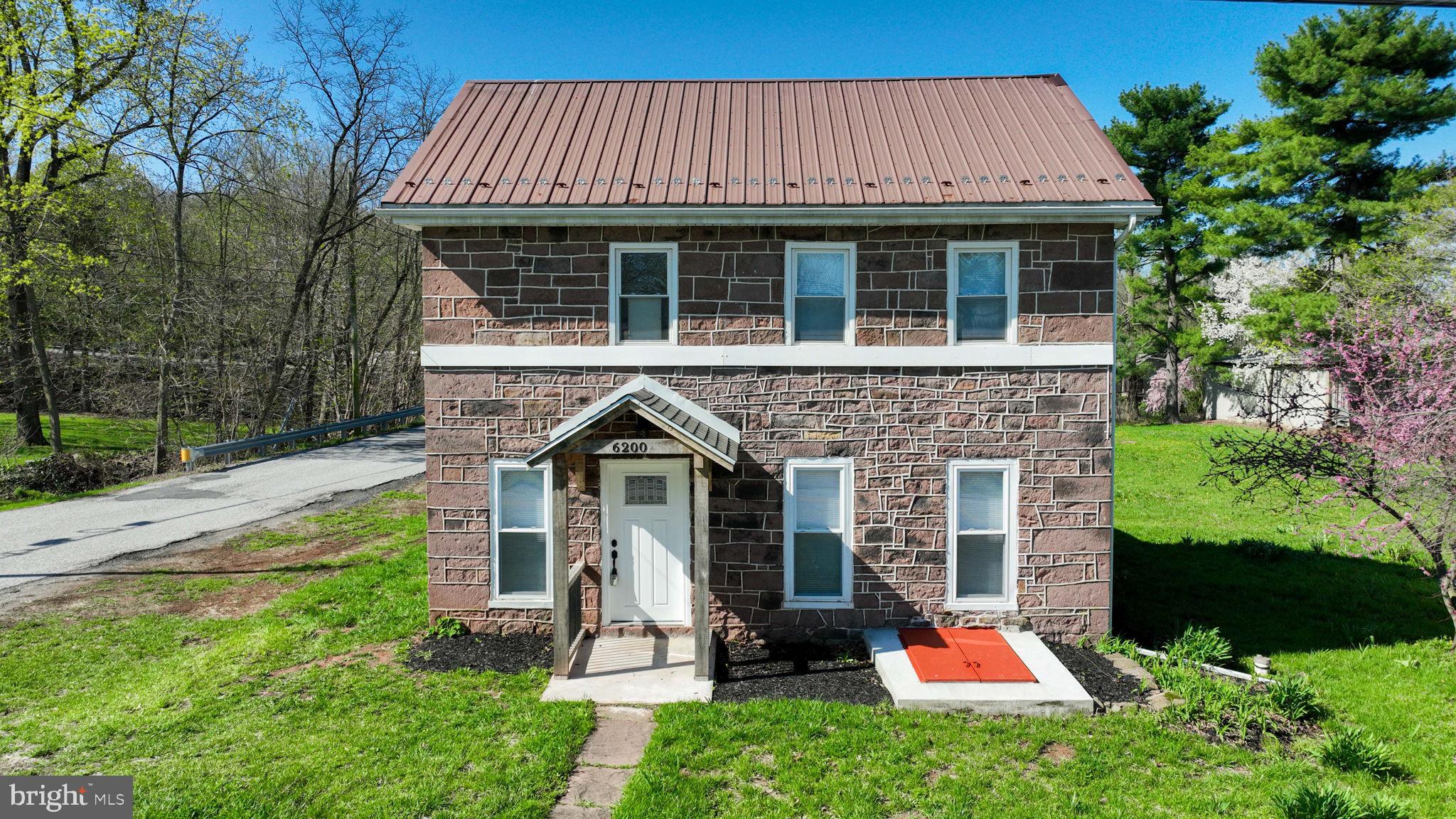 A perfect blend of historic charm and modern updates, this stone exterior home sits on a desirable corner lot with off-street parking for multiple vehicles, a spacious yard, and a storage shed. Inside, you’ll find a bright, open layout with modern plank flooring flowing through the kitchen, dining, and living areas. The main level includes a convenient first-floor bedroom and full bath. A formal dining room opens seamlessly to the kitchen and living space—ideal for entertaining. The kitchen is highlighted by a vaulted ceiling with exposed wooden beams, gorgeous quartz countertops, a center island, and stainless steel appliances. The living area features a powder room and wall-to-wall windows that fill the space with natural light. Upstairs, you’ll find a versatile loft area, an additional full bath, and two generously sized bedrooms. Great location - minutes to restaurants, shopping, and local amenities.