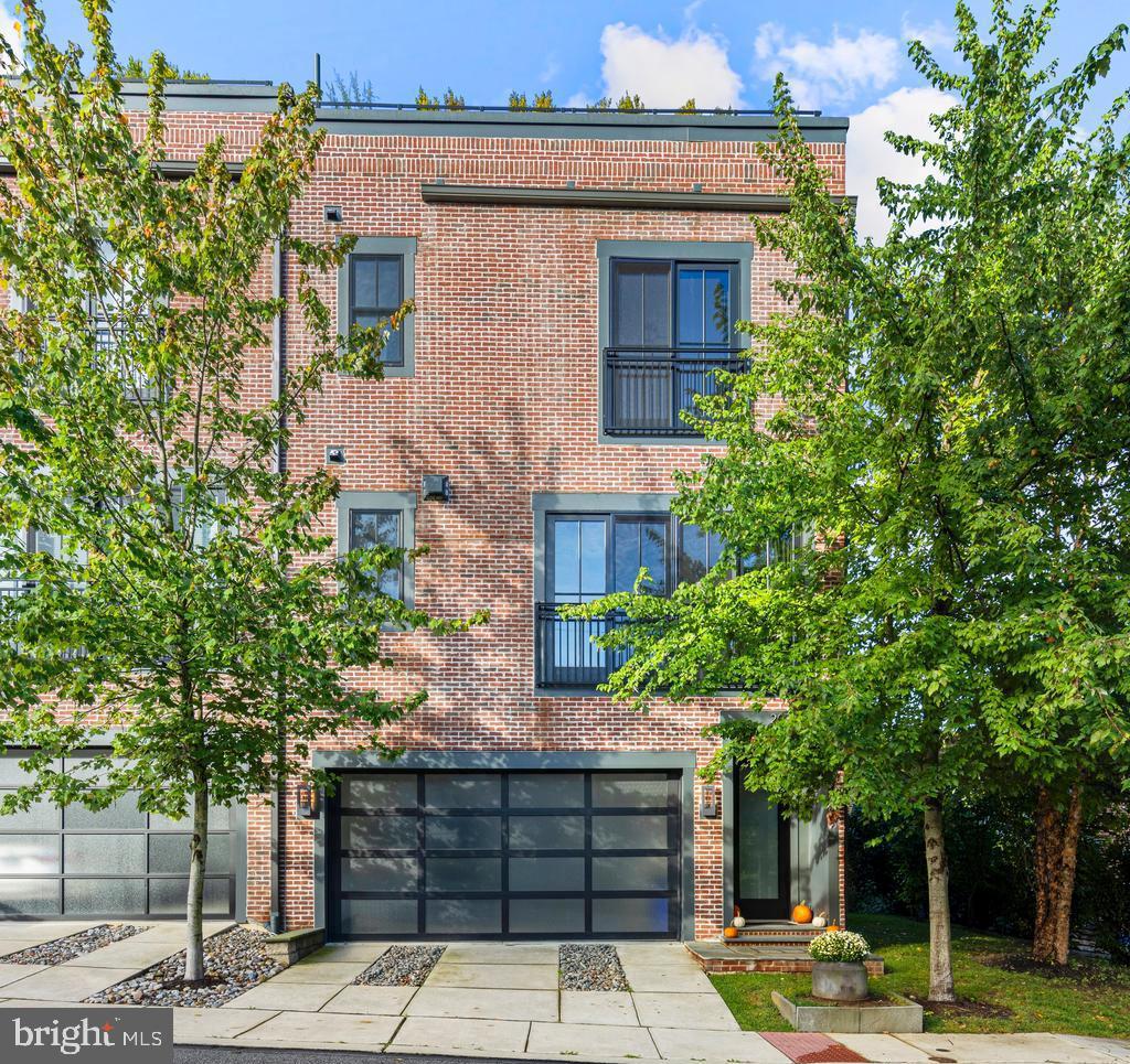 The townhomes at Plant & Willow take their cues from the character of old factories and warehouses—spaces once purely utilitarian, now celebrated as design icons. This community leans fully into the “Industrial Chic” aesthetic, highlighting expansive windows, dramatic ceiling heights, exposed brick, and architectural post-and-beam details. At 207 Willow Avenue, a 4-story END-unit townhouse, you’ll find all of this and more—plus spectacular views from oversized windows and the option for future elevator installation. From the moment you arrive, the striking brick façade and sleek garage doors set the tone for what awaits inside. Step through the front door and prepare to be impressed by floating staircases, designer lighting, impeccable finishes, and sunlit spaces on every level. The entry level provides garage access with smart wall organizers, a utility/storage closet, and a spacious 3rd Bedroom which could also be used as a Study/Office. This room also has 2 closets and an en suite 3rd Full Bathroom with a floating vanity and designer tiled shower. The ground floor Hallway features upgraded tile flooring (chosen over the builder’s standard concrete) for a clean, polished feel.  There is ample space under the stairs for exercise gear, a desk, or cubbies.  Closets on each level were aligned to make this home ELEVATOR-ready and the HOA dues are very LOW compared to most turn-key communities.  Ascend to the main level,, which offers true loft-inspired living. Here, the gourmet Kitchen shines with honed black counters, open shelving, lift-up glass cabinets, a walk-in pantry, and an enviable appliance package with Thermador 4-burner gas cooktop with griddle, wall oven, microwave, and dishwasher plus a KitchenAid French-door refrigerator 
The island features breakfast bar seating for casual dining or enjoy hosting family and friends in the spacious Dining Area.  The Living Room adds even more style with an exposed brick wall, sleek gas fireplace, and treetop views framed by oversized windows. A Powder Room completes this level, perfect for guests. Upstairs, hardwood floors continue throughout. The spacious 2nd Bedroom offers large windows, built-in shelving, and track lighting, while the Hall Bath echoes the sleek design of the lower levels. The Laundry Room is oversized with plenty of storage space. The Primary Suite is a retreat in itself—boasting tree-top views, two walk-in closets with custom organizers, and a luxurious Bathroom featuring a floating double vanity, oversized tile shower with multiple shower heads and jets, and modern lighting. The rooftop deck is the showpiece: finished with wood decking, planter boxes, accent lighting, and a natural gas fire pit. It’s the perfect backdrop for sunset gatherings, summer barbecues, or quiet evenings under the stars. Additional upgrades set this home apart: all closets include custom built-ins, recessed lights are smart-controlled, and premium Shade Store window treatments are already in place. Every design choice reflects a refined taste that the next owner will enjoy for years to come.
Only 3/10 mi. from Wayne Train Station!  Take N. Wayne Ave. to R/Pennsylvania Ave. to L/Plant to L/Willow.