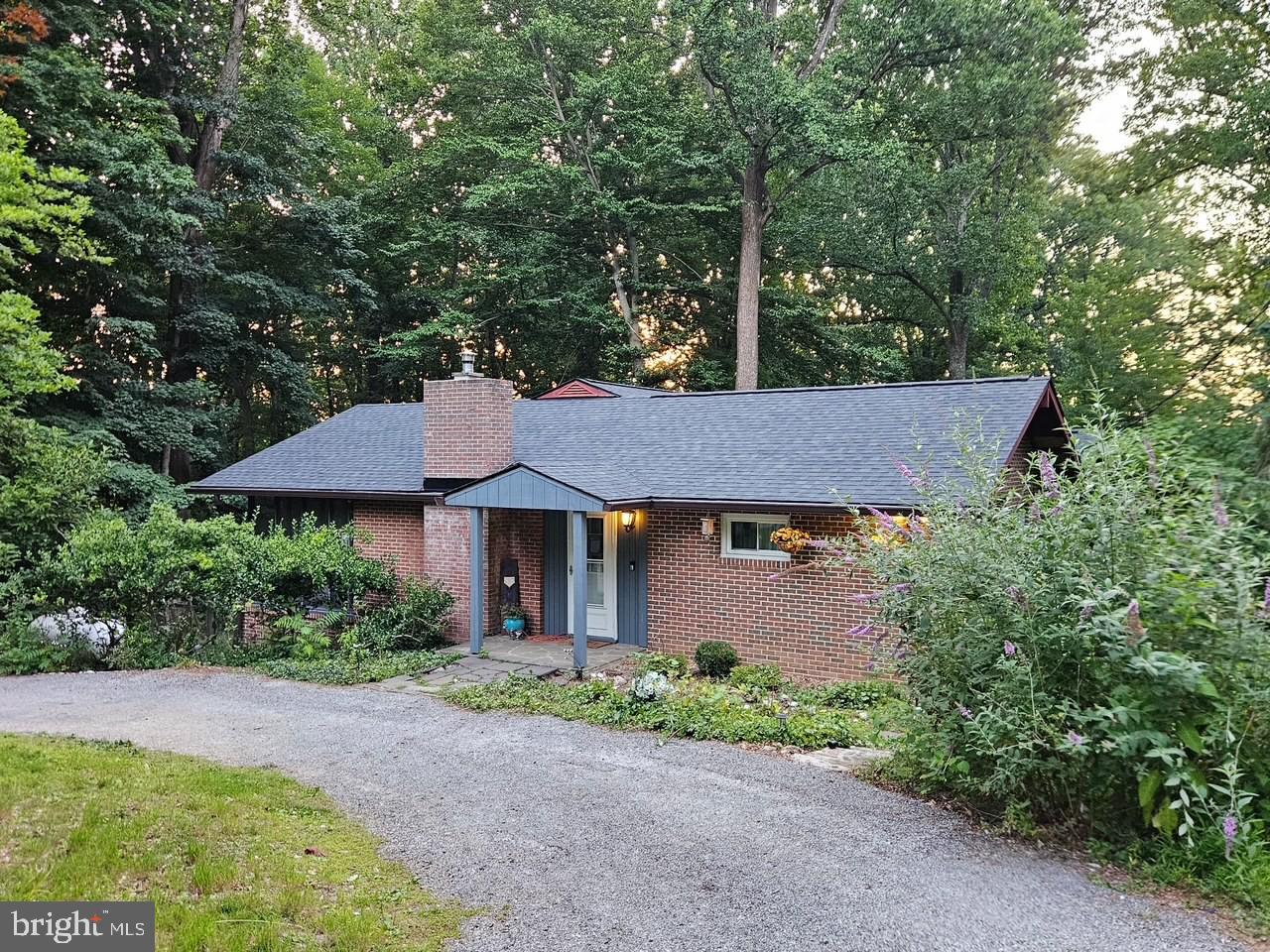 Tucked among the trees, this charming ranch home offers the perfect blend of privacy, comfort, and modern updates. With new windows, new kitchen, and a new deck completed within the last two years—and a brand‑new roof being installed prior to closing—this home is truly move‑in ready. Set on nearly two acres, the property features extensive yard space, a second driveway, and access to the under‑home garage. Inside, you’re welcomed by a spacious great room with vaulted ceilings and an easy flow into the open kitchen and dining area. Recent renovations include stunning royal‑blue cabinetry, Quartz countertops, and a long stretch of workspace ideal for entertaining, with room to add an island if desired. A bright, sunny bank of windows overlooks the rear yard, bringing nature indoors. The living room features a newly re‑lined wood‑burning fireplace for cozy winter nights, and both the kitchen and living room open to a large screened‑in porch—perfect for morning coffee or evening relaxation without any pesky visitors. The main level includes a primary bedroom with an ensuite bath and private covered porch, two additional bedrooms, and a full hall bath. The lower level offers garage access, a large storage room with partial crawl space, and a finished bonus room that can serve as a rec room, flex space, or home office, complete with walk‑out access to the yard, a half bath, and a laundry room. Outside, enjoy a maintenance‑free deck, mature landscaping filled with native plants and trees, and the flexibility to clear areas for more open yard space if desired. The second driveway, owned by this property, provides additional parking and convenient access to the garage. Though tucked away in a peaceful setting, the home is close to Liberty Mountain Ski Resort and Golf Course, Historic Gettysburg, and major commuter routes to Frederick County and beyond. Originally built in 1966 as part of the Carroll Valley vacation‑home community, the home later transitioned to full‑time living with a rear addition added around 1980. Sellers are relocating and ready to find their home of choice—come experience this inviting retreat for yourself. #staycation #carrollvalley #homeowner2026