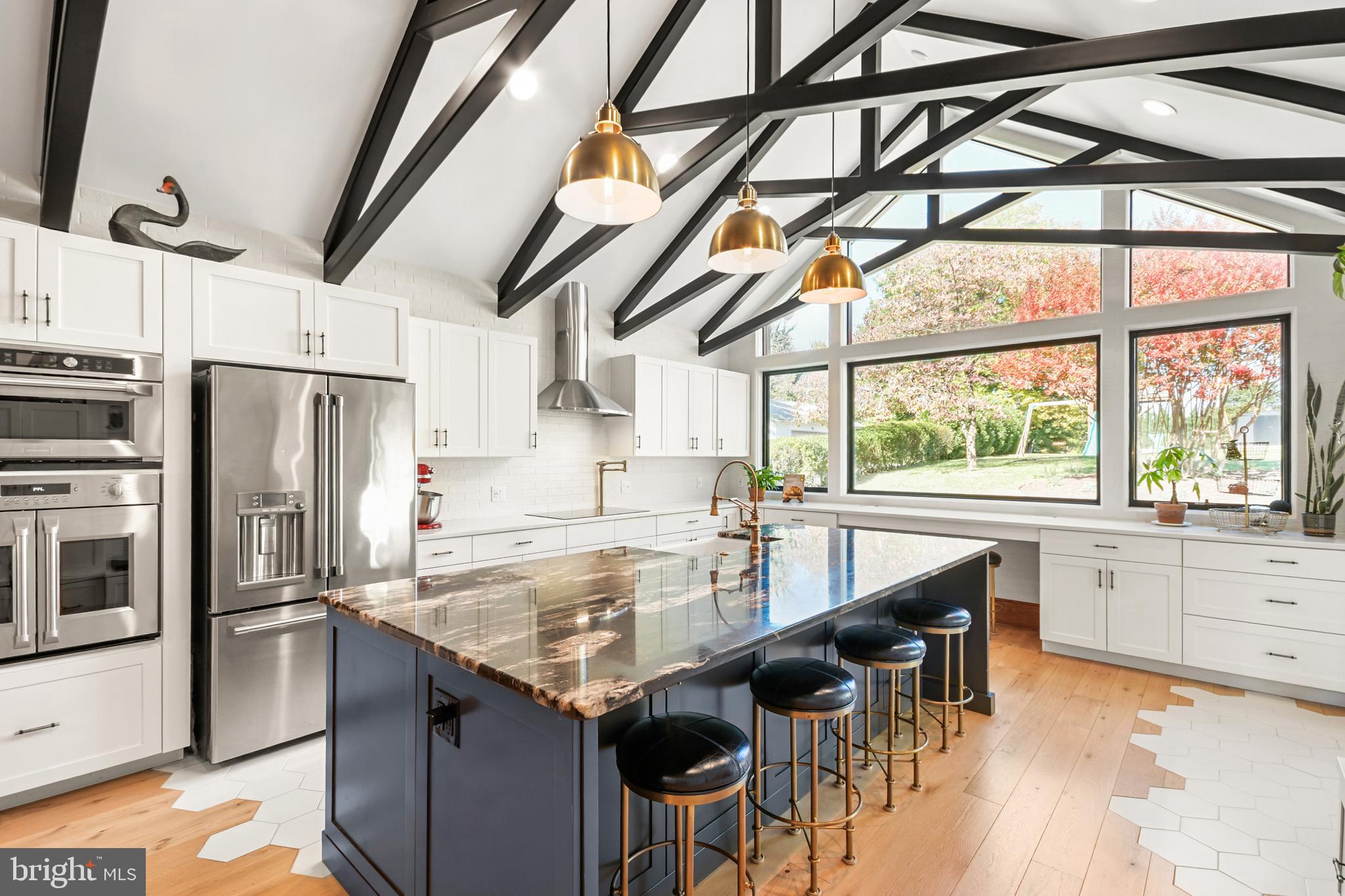 Carefully reimagined between 2018 and 2021, this historic Main Street home now lives like a luxury boutique retreat hidden in the heart of Middletown — complete with a secret speakeasy concealed behind a swinging bookshelf, a breathtaking custom kitchen addition, and a covered courtyard entertaining area anchored by a stunning stone fireplace. Rich in history yet thoughtfully transformed for modern luxury living, this extraordinary four-bedroom residence with dedicated office space blends timeless craftsmanship with sophisticated design rarely found in historic homes. Perched above historic Main Street with sunset views toward South Mountain, the home showcases soaring ceilings, original architectural details, custom Mennonite-crafted millwork, designer Circa lighting, and extensive infrastructure updates throughout.

At the heart of the home is the stunning kitchen addition featuring exposed historic brick, dramatic steel scissor-beam trusses, handcrafted cabinetry, quartz perimeter counters, granite center island, GE Monogram appliances, farmhouse sink, induction cooktop, and a dramatic picture window overlooking the beautifully landscaped courtyard and covered side porch. The original kitchen was transformed into a spacious dining room, creating exceptional flow for entertaining while preserving the home’s historic character. Outdoor living spaces feel like an extension of the home itself with stamped concrete, custom stone fireplace, a covered entertaining area, integrated storage, and beautifully landscaped gathering spaces designed for both intimate evenings and large-scale entertaining.

The front parlor was transformed into a stunning library with built-in shelving, restored historic shutters, statement lighting, and the hidden swinging bookshelf leading to the speakeasy featuring a solid wood bar, wet bar, beverage refrigerator, custom ceiling paneling, and dramatic finishes. The family room was created by opening two original parlors and is crowned by a dramatic bay window that floods the space with natural light.

Upstairs, the home offers two primary suites along with spacious secondary bedrooms featuring exceptional flexibility, including a custom Murphy bed/work table system and built-in bay window seating. A dedicated office conceals a hidden opening into an untouched portion of the original home, creating a fascinating preserved time capsule rarely found in homes of this era. A covered upper porch overlooks the courtyard below, while the redesigned laundry room introduces marble countertops, statement lighting, and additional storage.

The finished attic was transformed into a truly unique owner’s retreat featuring reclaimed oak flooring, exposed brick chimneys, preserved historic wall surfaces, dressing room, laundry chute, separate staircase access, and a spa-inspired bath with a hidden Japanese-inspired Ofuro soaking tub room.

Infrastructure improvements include dedicated high-end Carrier HVAC systems with hospital-grade filtration and smart thermostats, radiant heated floors, replaced electrical systems in 2020, updated copper plumbing, Japanese toilets, hand-tooled standing seam metal roof, replacement gutters, energy-efficient wooden sash windows, composite porch decking, central vacuum, Sonos integration, and extensive custom woodworking throughout.

Stretching from Main Street to West Green Street, the property also includes a subdivided, buildable rear lot. The purchaser of 19 E Main Street will have first right of refusal on the lot, which is also available separately, creating a rare opportunity for future expansion or investment in the heart of Middletown.

Located on one of Maryland’s historic designated Main Streets, just steps from Middletown’s restaurants, library, shops, parks, & sought-after schools, this extraordinary residence offers a lifestyle as rare as the home itself.  Owned by only three families in 100+ years, this one-of-a-kind home blends history, luxury, & craftsmanship.