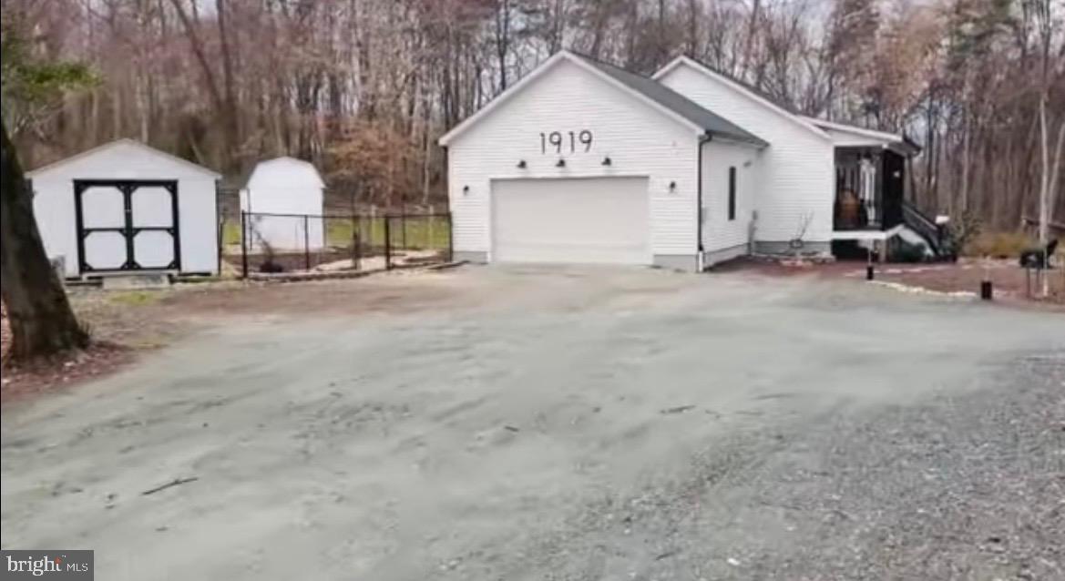 MOTIVATED SELLERS! HOA is minimal, has no restrictions. Location, location, location! Just a few minutes from Ft. Meade and NSA; close to Arundel Preserve, Columbia, BWI airport, and Jessup park is a .5 mile away. Calling all nature and project lovers, and/or those who are homestead dreaming! 3-year-old modular home (known for their solid construction) enveloped with tree coverage and conservation acreage. This is a gorgeous .92 acre lot with house located 300' off of the main road, offering one of the most private lots in the area for its size. It is homestead-ready with a new Amish-built mini barn and shed, two black chain link fenced areas with latch gate connecting the two, inviting front porch and a large partially screened back deck with high-end Jetsetter LX salt-system hot tub. Finished basement, approx 1500 on main (2bed, 2bath) and 1500 on lower (1bed, 1bath). Security system hardware included. Main Level: double-sided (primary suite & LR) propane fireplace, plantation shutters throughout, gorgeous antique-style large blade ceiling fan in primary, additional ceiling fans (office, L/R, and 2nd bedroom), box ceiling in primary, sliding glass doors off of primary bedroom offer beautiful view of trees and walkout access to hot tub, artisan clay tiles in kitchen, quartz kitchen countertops and copper sink, french glass doors for office (perhaps use as extra bedroom or dining room), two separate vanities/sinks in primary bath, large shower with clay tiles, large walk in closet attached/behind primary shower, 2nd bathroom has tub/shower, laundry room with sink, open kitchen and L/R area with high counter bar with dark copper L-brackets, wide garage. Basement: a separate front entrance, perfect for an additional dwelling, home gym/exercise space, and/or a home business. Lower was used as dance studio space and massage room, has floating/sprung floor and mirrors along two of the longest walls, and installed curtain tracks to divide areas if desired. Brass sink vanity in bathroom, copper shower basin, clay floor tiles, plenty of closet/storage space. Exterior: drink your morning coffee/tea and watch deer from the front porch as they cross the 300' gravel driveway and opposite side of the property, lots of guest parking, circle drive option around biogarden, black gutters and downspouts, 50 amp installed for RV and septic drop, lavender garden, fig tree, two weeping willows, yews, berry vines and bushes, butterfly garden that brings in annual monarchs, extra large hostas, small veg garden, compost area, etc.,..and there is lot of empty space to work with to make it your own oasis. Home selling as is, owners moving soon.