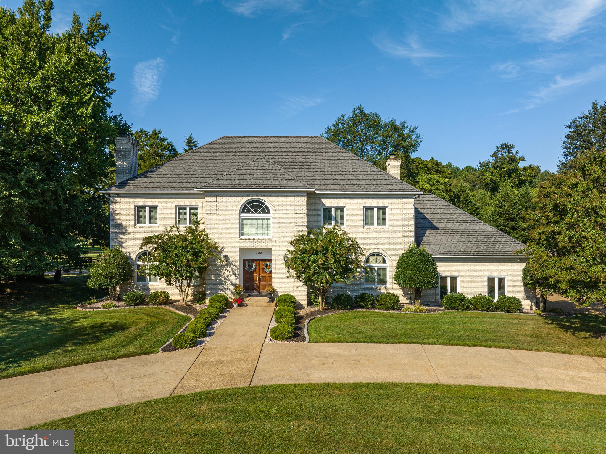 Nestled on a sprawling 5-acre estate, this all-brick colonial home offers an unparalleled blend of elegance, comfort, and outdoor splendor.  Boasting 6451 sq. ft., 4 bedrooms and 4 ½ baths, this equestrian residence presents an exceptional opportunity for those seeking a sophisticated retreat with ample amenities.
Guests are greeted by a grand two-story foyer, adorned with stunning marble floor.  The spacious living room and dining room feature gleaming hardwood floors that flow seamlessly throughout the rest of the main level.  The heart of the home lies in the expansive kitchen, appointed with a large island, granite counter, ideal for both casual dining and gourmet meal preparation.   French doors lead from the inviting family room to a deck, providing the perfect setting for outdoor entertaining or serene relaxation.
Upstairs, four generously sized bedrooms await, including an opulent owner’s suite complete with a beautifully appointed bathroom.  An ensuite bedroom and two additional bedrooms with a shared buddy bathroom offer ample space for family and guests.  The lower level of the home features a large walk-up basement, boasting a wet bar, overhead projector and wine storage for up to 300 bottles.   A bonus room and full bathroom add versatility to the space, accommodating a variety of lifestyle needs.
Stepping outside, the property reveals an array of outdoor amenities, including a sparkling swimming pool with extensive patio, perfect for soaking up the sun on warm summer days.  Equestrian enthusiasts will appreciate the 2-stall barn with tack room and electricity, haybarn/storage, small, enclosed riding area, and two large paddocks with water access.  Nearby trails provide endless opportunities for exploration and adventure.  With its breathtaking bucolic views and impeccable attention to detail, this extraordinary property offers a rare opportunity to experience luxury living amidst the beauty of nature.   Don’t miss your chance to make this exquisite estate your own!