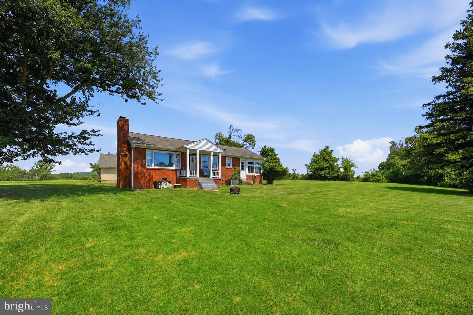 Charming brick rambler set on over three gently rolling acres!  Serene views from the patio & front porch or just relax under the mature trees in front!  Hardwoods through most of the home! Detached garage with plenty of space for storage or workshop - Sun room lined with windows makes for an ideal home office with idyllic views!