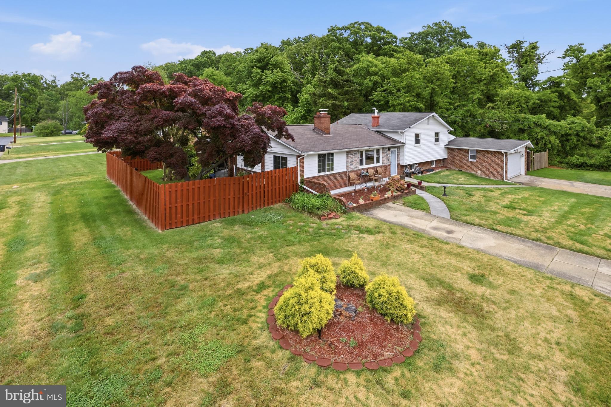 Welcome to this beautifully maintained split-level single-family home, perfectly situated on a stunning corner lot that offers both space and curb appeal. This property stands out with its oversized three-car garage and dual driveways, providing ample parking and convenience for guests and everyday living.

Step inside to discover a warm and inviting interior featuring a gorgeous kitchen with rich hardwood floors—perfect for both daily living and entertaining. The upper level offers three spacious bedrooms, while the lower level includes an additional bedroom, ideal for guests, a home office, or multi-generational living.

Enjoy multiple living spaces, including an expansive lower-level family room that walks out to a covered back patio—perfect for relaxing or hosting gatherings year-round. The fenced-in yard provides privacy and plenty of space for outdoor activities.

Cozy up by one of the home’s two fireplaces, adding charm and comfort throughout the seasons. With its thoughtful layout, generous features, and prime corner location, this home is the perfect blend of functionality and style.

Don’t miss the opportunity to make this exceptional property your own!
