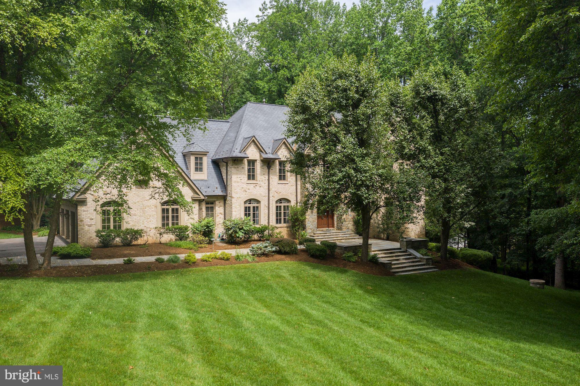 Escape from the bustle of busy city life to your personal retreat - a beautifully designed and completely custom built 5-6 bedroom, 5.5 bath Manor house, with roughly 8,500 finished sq ft, sitting on a private 2 acre lot.  You are welcomed into a gracious 2 story foyer with marble floors and an elegant staircase leading to the 2nd floor gallery. The special architectural details in this grand home are noted everywhere. Elegant curves in the design bring warmth and interest with arched doorways, transoms, bay windows, and the elegant curved staircase. Even the steps down into the living room create a graciously transition. Each room on the main level can be closed off using french doors or solid wood 6 panel pocket doors, some of which are beautifully arched to match the entrance to the room.  Five fireplaces with marble surrounds can be found throughout the home. The Pella windows create a backdrop of nature in every room. The family room has floor to ceiling windows, plus a wall of built in custom cherry paneling, cabinets and mantle surrounding the fireplace. The magnificent study has masterful paneling with tall windows, a fireplace, and a wet bar with refrigerator. A true executive’s office or separate cozy den for quiet reading or more intimate entertaining. Kitchens are often the gathering place for the family or guests. This beautiful, bright kitchen is bright and welcoming. With white lacquer cabinets, Thermador appliances, including a 6-burner range (both electric and gas), Corian countertops, double ovens and an island for casual conversation or work, there is a space for everyone in the household to gather. And there is room for a larger table for more to sit down together.  A separate laundry room with sink and counter space is off the kitchen. Walk upstairs, either by the front staircase or a second staircase from the kitchen, to an incredible primary suite with a large sitting area surrounded by windows, a gracious bedroom with lovely gas fireplace. There is also a dressing area with 2 large walk-in closets that lead to the beautiful bathroom with marble floors, glass shower and deep soaking tub. There is a bonus room off the master bathroom with a wall safe that conveys and has lots of extra storage. This room has numerous potential uses! Convert it to an upstairs laundry, yoga or exercise room, additional dressing room, or private retreat. Three additional spacious bedrooms and two full baths surround the upper gallery.  Just as there are 2 staircases up to the bedroom level, there are 2 staircases leading down to the walk-out basement. The expansive finished basement is complete with a large parquet dance floor, another gas fireplace with custom maple mantle, a media room with custom maple entertainment center, a custom mahogany and granite bar with dishwasher AND a climate controlled wine cellar. For smaller gatherings there is also a bonus room, bedroom and 2 full bathrooms!  The bonus room has french doors leading to the main rec room. It could be used as another bedroom, den or game room or create a suite with this as the sitting room to the separate bedroom. The basement walks out to one of several slate patios.  The owners once had a hot tub out there. It has been removed but the wiring is still there to help you create your own outdoor entertainment. The exterior of this spectacular home offers many options as well.  There are 2 places on the 2 acre lot that allow for a pool or level playground.  And there is one section of flat land that could also accommodate a tennis court! Just think of all the possibilities you can create in this spectacular home. Additional features include a massive 3-car garage, an in-ground sprinkler system for the front and back flower beds, a central vacuum system, an integrated sound system, and abundant storage space!  Situated only minutes from Tyson’s Corner. This is truly a unique opportunity to take a beautifully crafted home and make it your own!